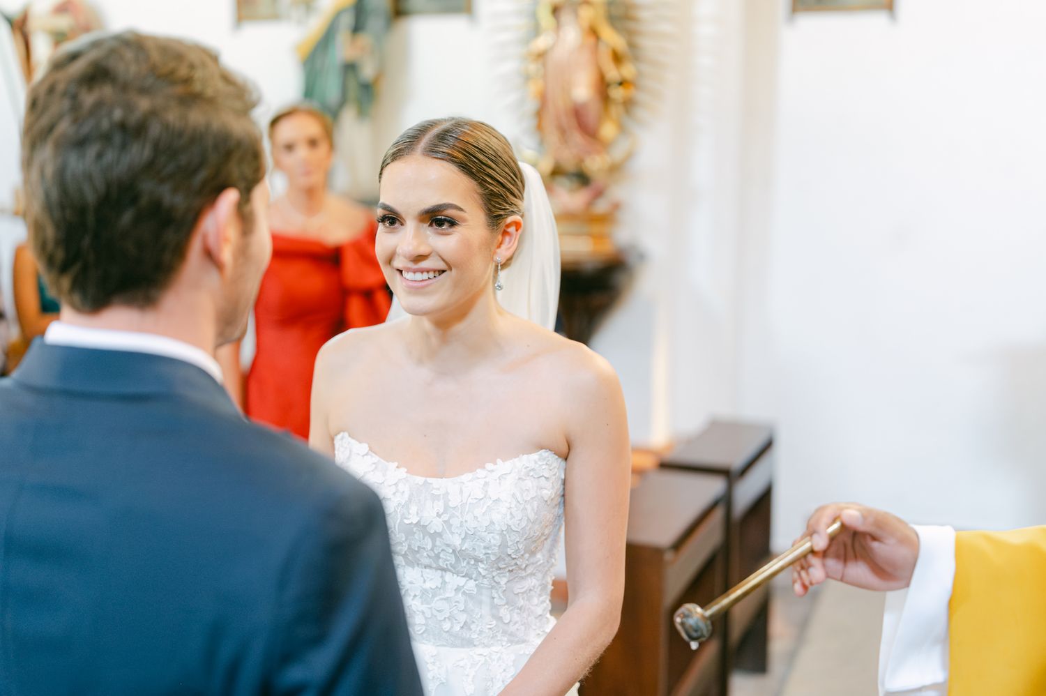 Exchange of rings during intimate wedding ceremony in traditional chapel setting.