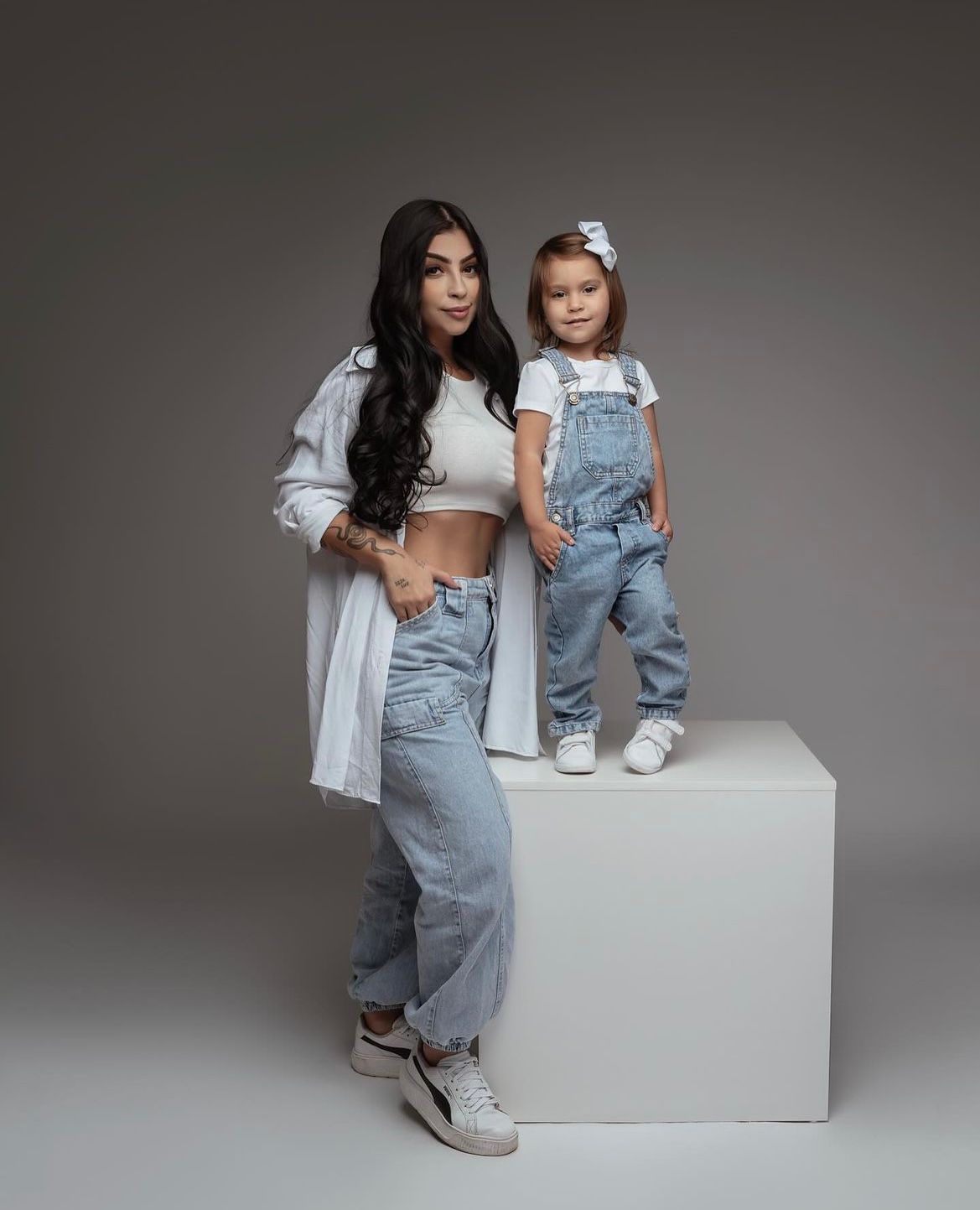 Matching denim outfits in minimalist studio portraits.