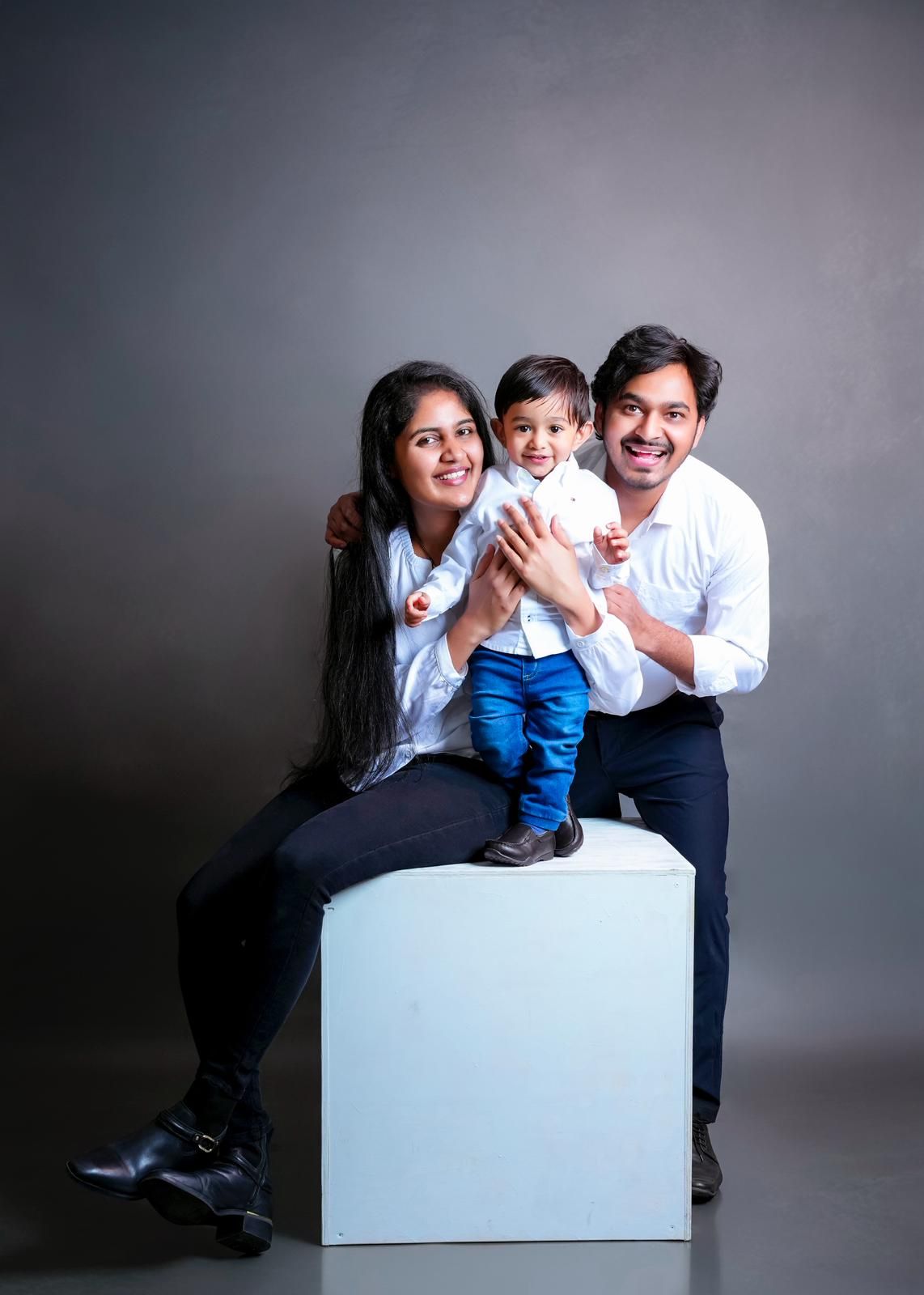 Studio family photos featuring white cube prop and coordinated outfits.