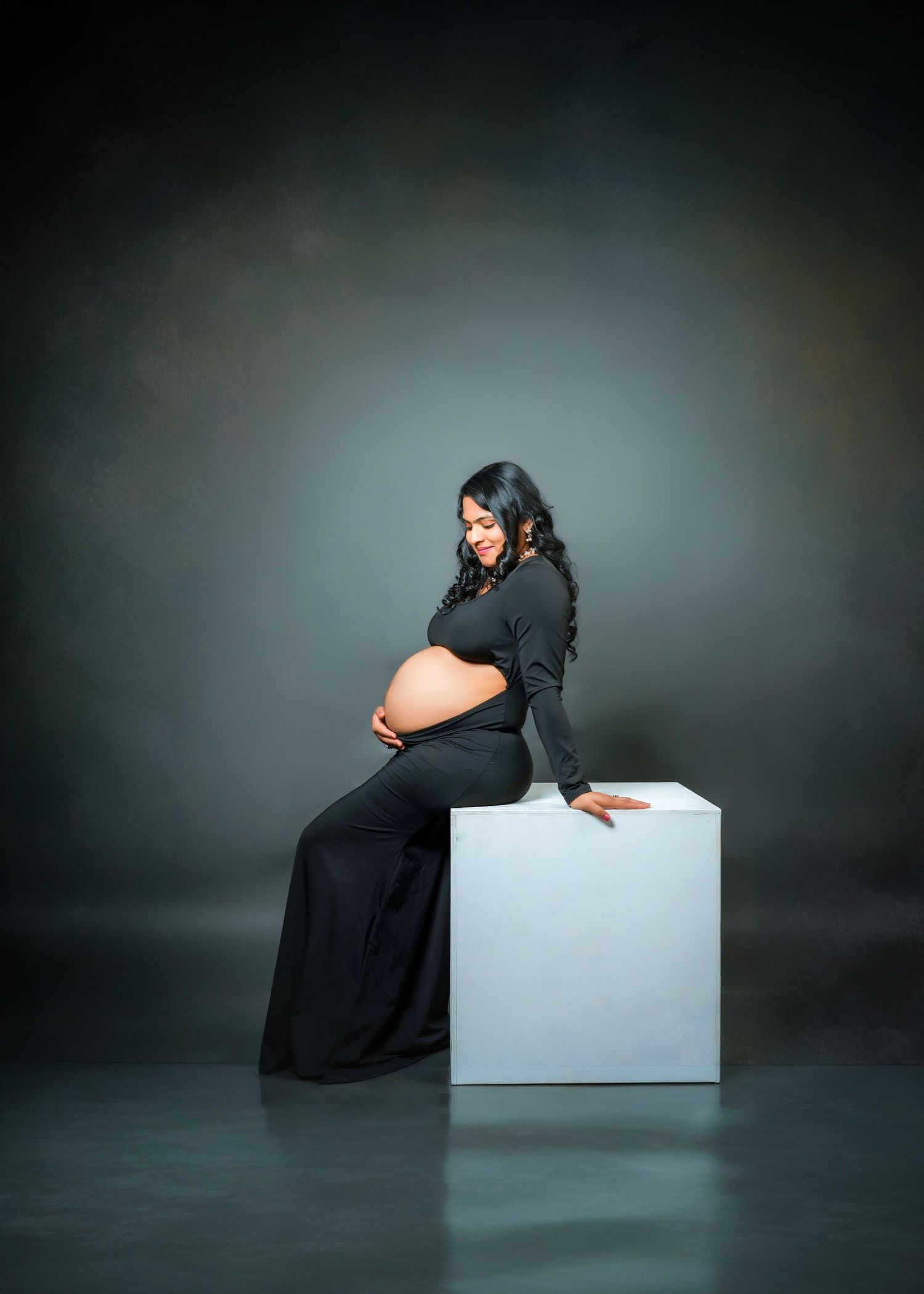 Artistic maternity poses with white cube prop against dark background.