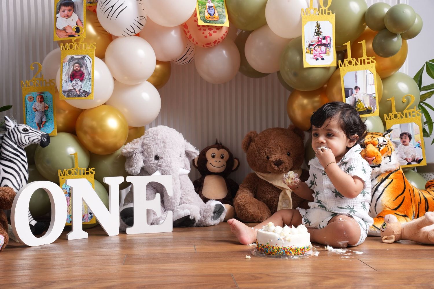 Safari themed first birthday party decorations with gold and pink balloons.