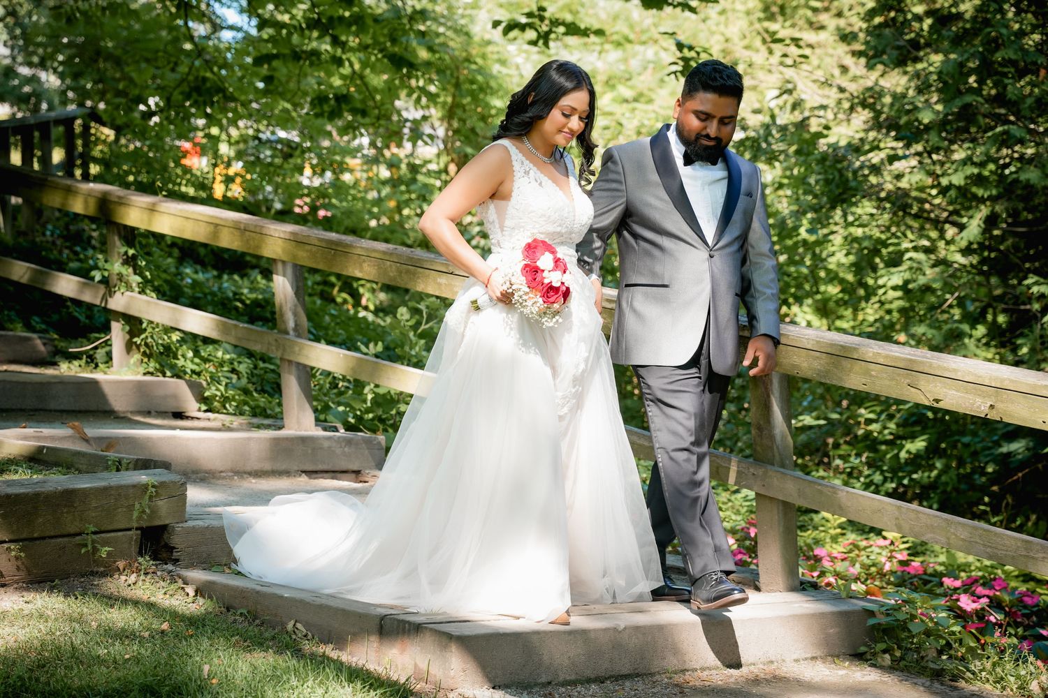 A couple poses on rustic wooden steps during an outdoor wedding photoshoot.