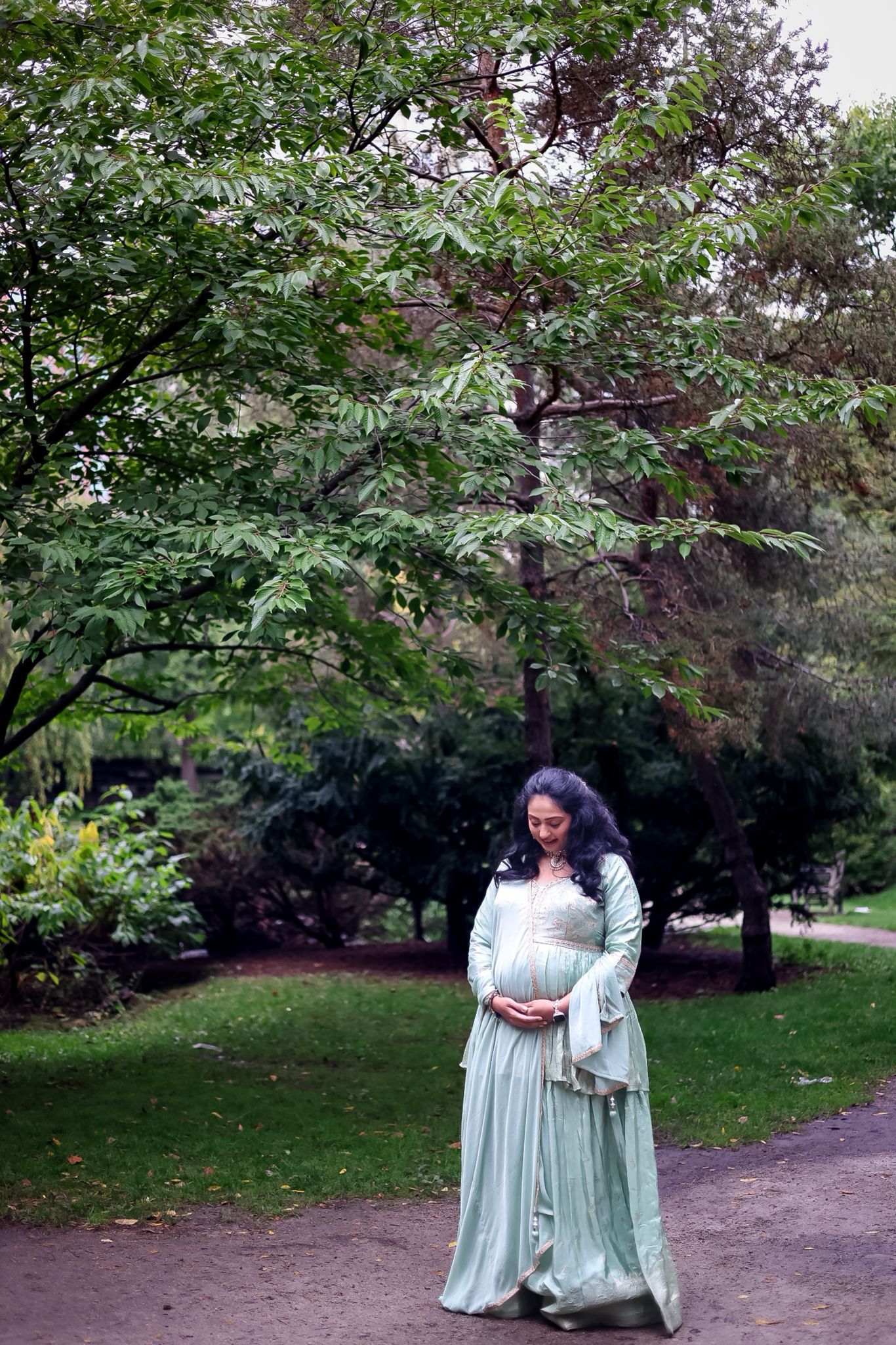 A mint green dress flows gracefully through an autumn park setting.