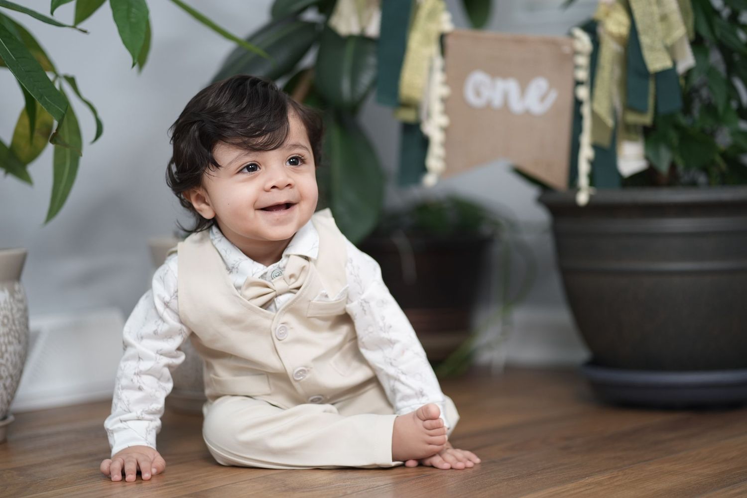 Baby milestone photo shoot with jungle theme decorations and plush animals.