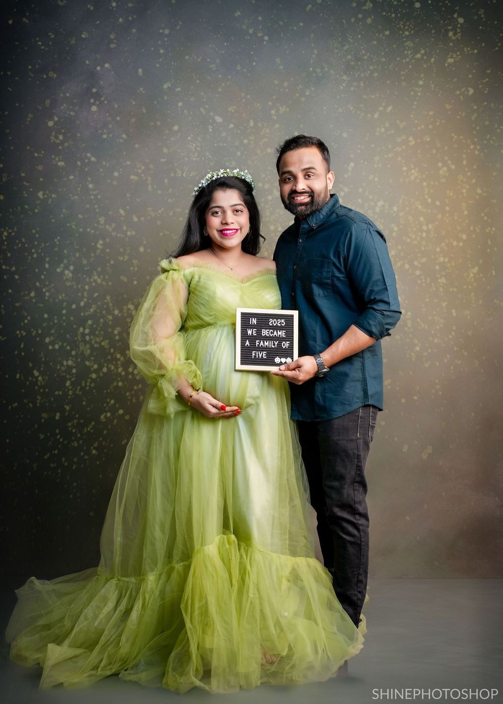 Maternity photoshoot featuring a flowing lime green tulle gown with sparkly backdrop.