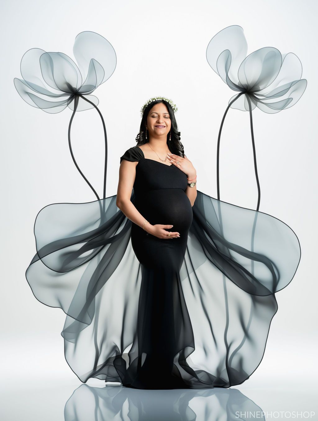 Artistic maternity portrait with translucent flower overlays in black and white theme.