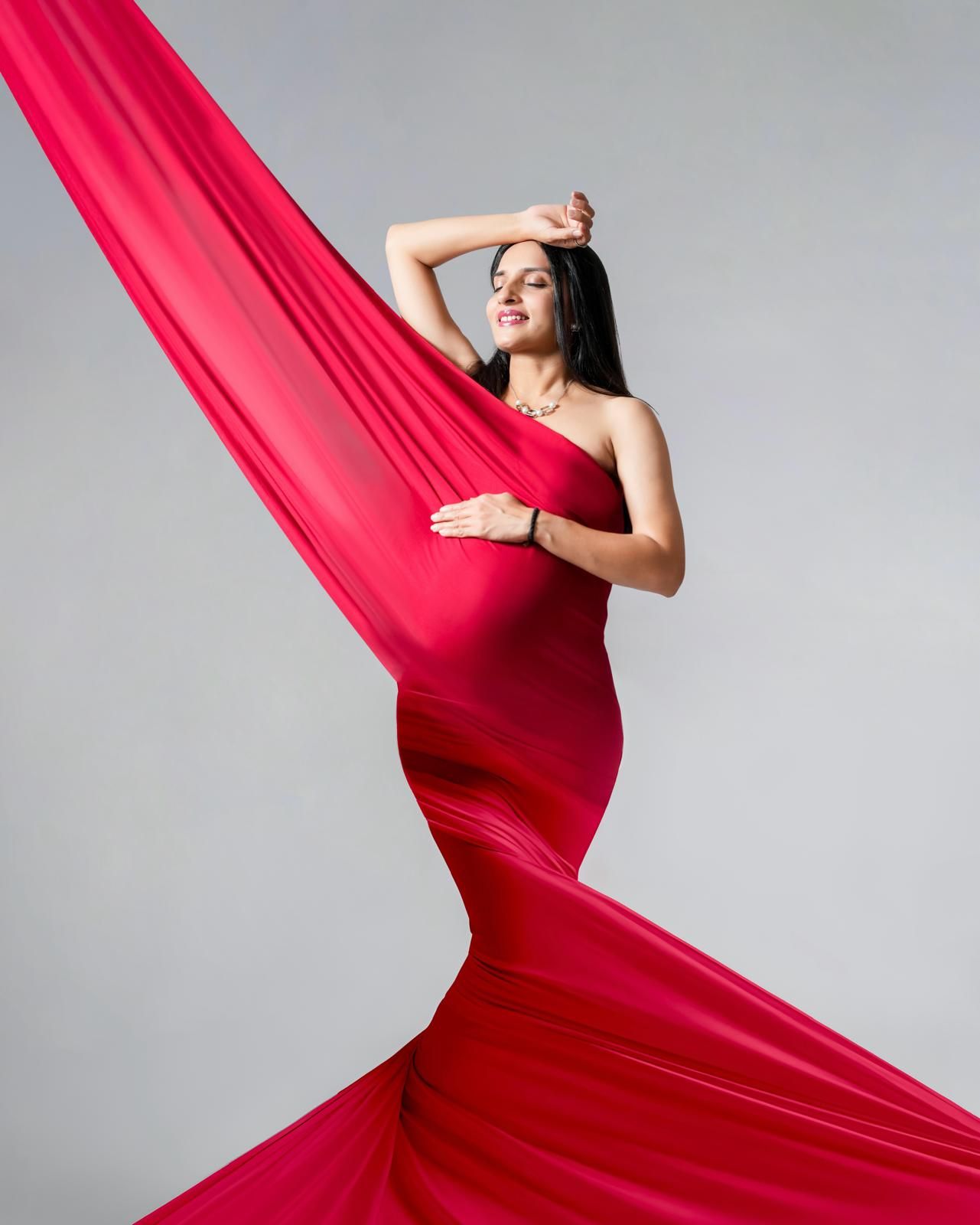 Flowing red fabric creates elegant curves and movement in studio photography.