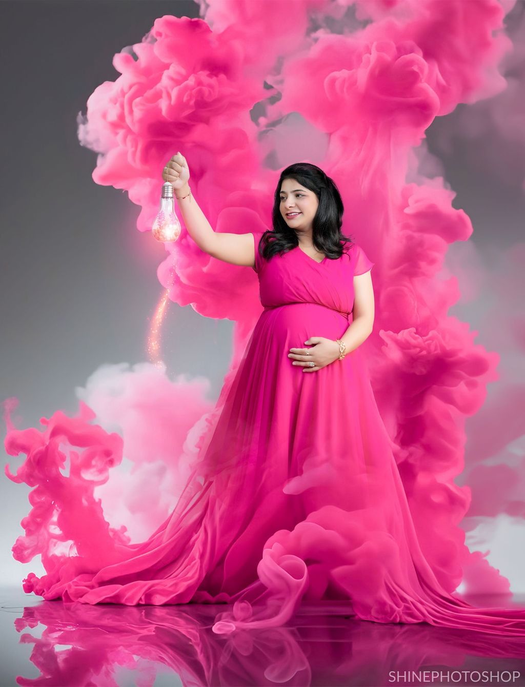 Creative maternity photos with bright pink smoke effects and flowing fabric against a grey backdrop.