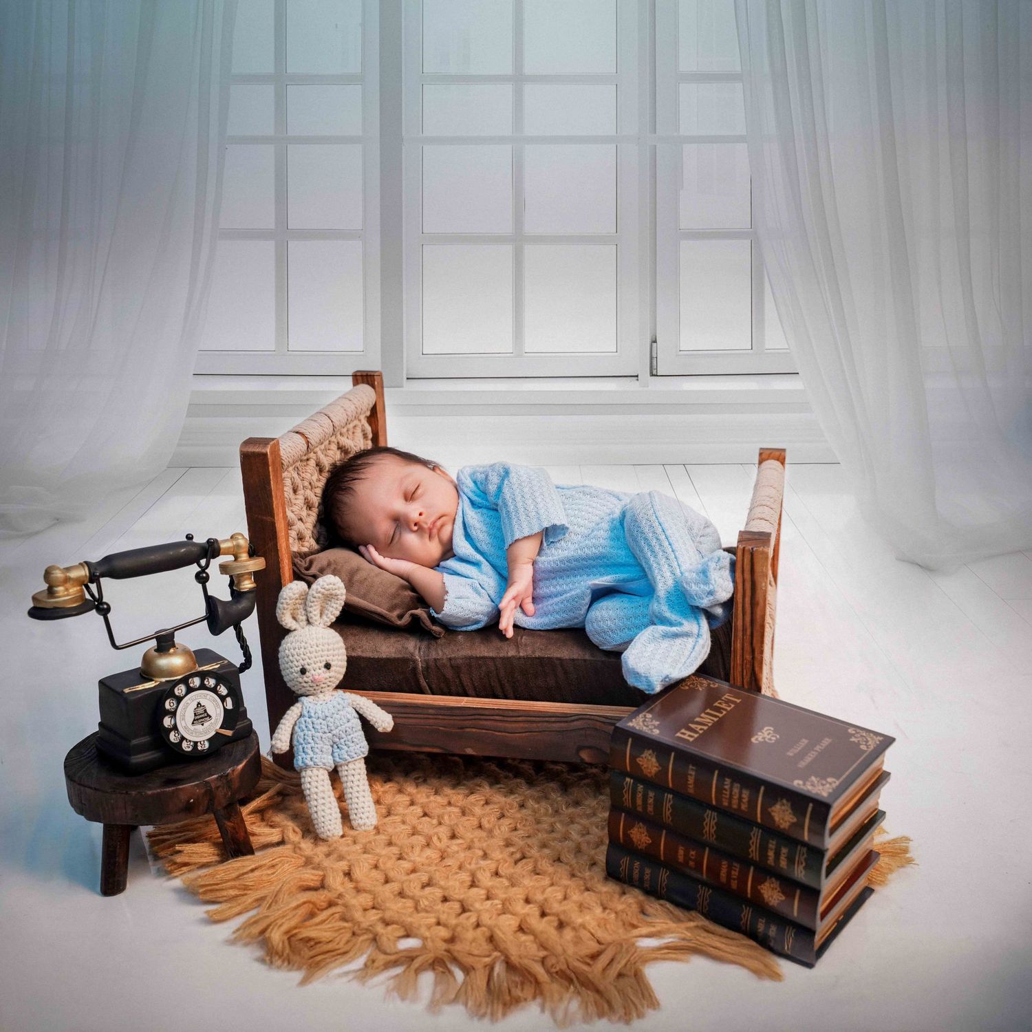 Vintage-inspired newborn photo setup with books, rotary phone, and plush toys.
