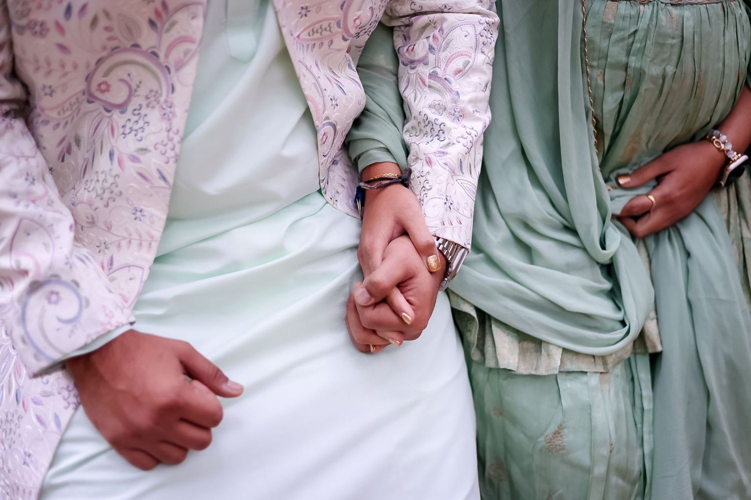 Close-up details of traditional South Asian wedding attire in white and mint green colors.