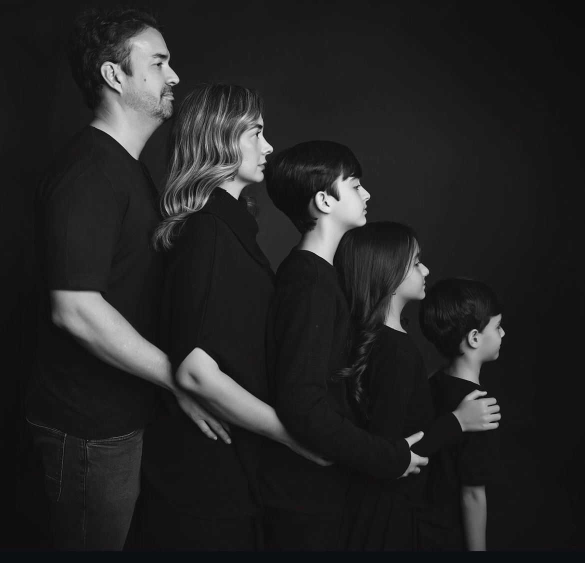 Dramatic black and white silhouette portraits showing tender family moments.
