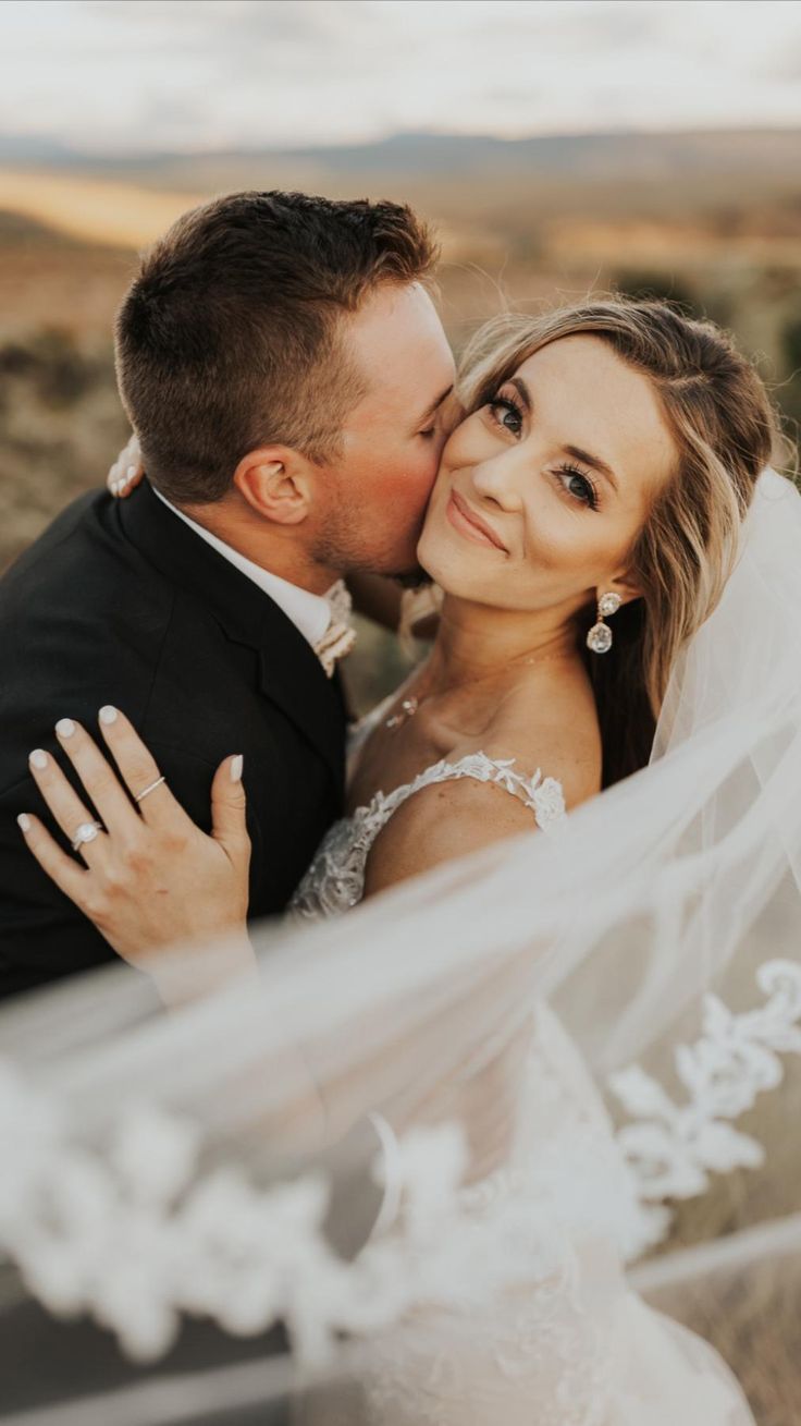 Romantic close-up shots of a couple kissing on their wedding day with a flowing white veil in the background.