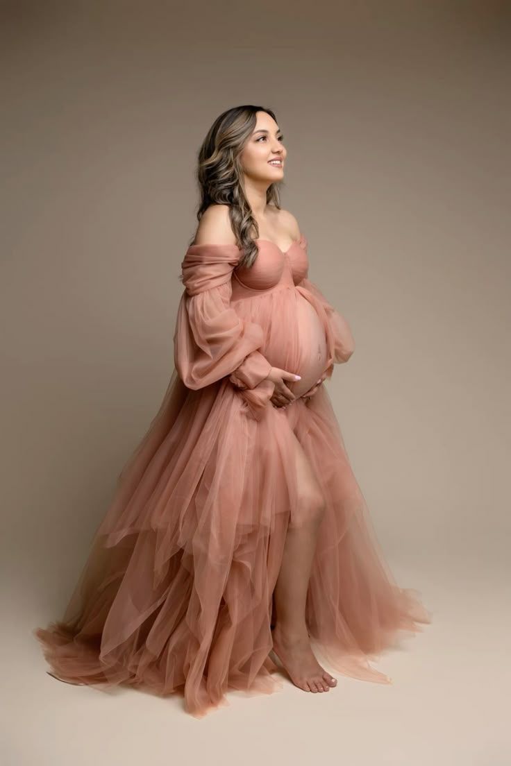 A flowing dusty rose tulle gown is showcased in an elegant maternity photoshoot sequence.