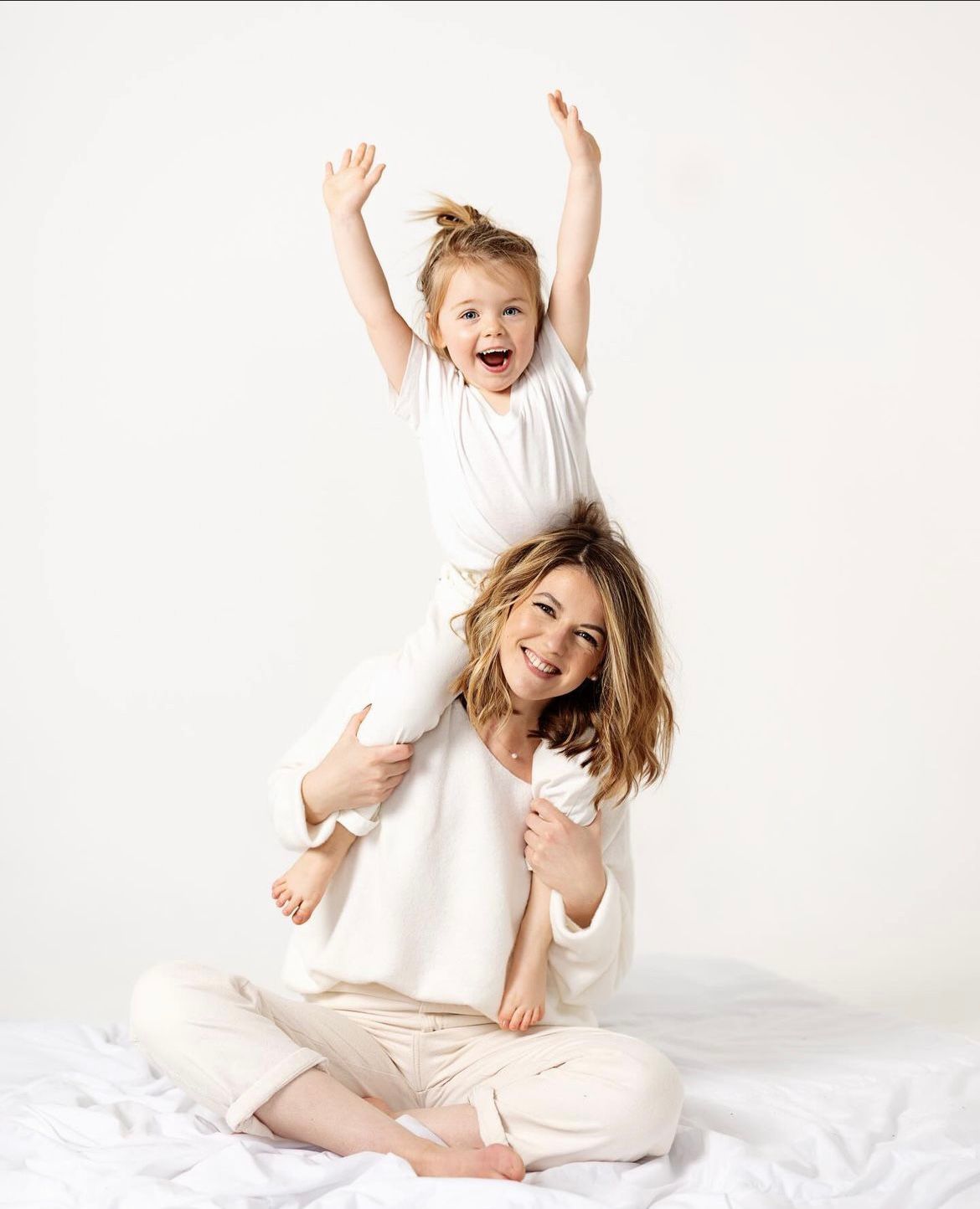 Playful white-themed family photoshoot with natural movements and expressions.