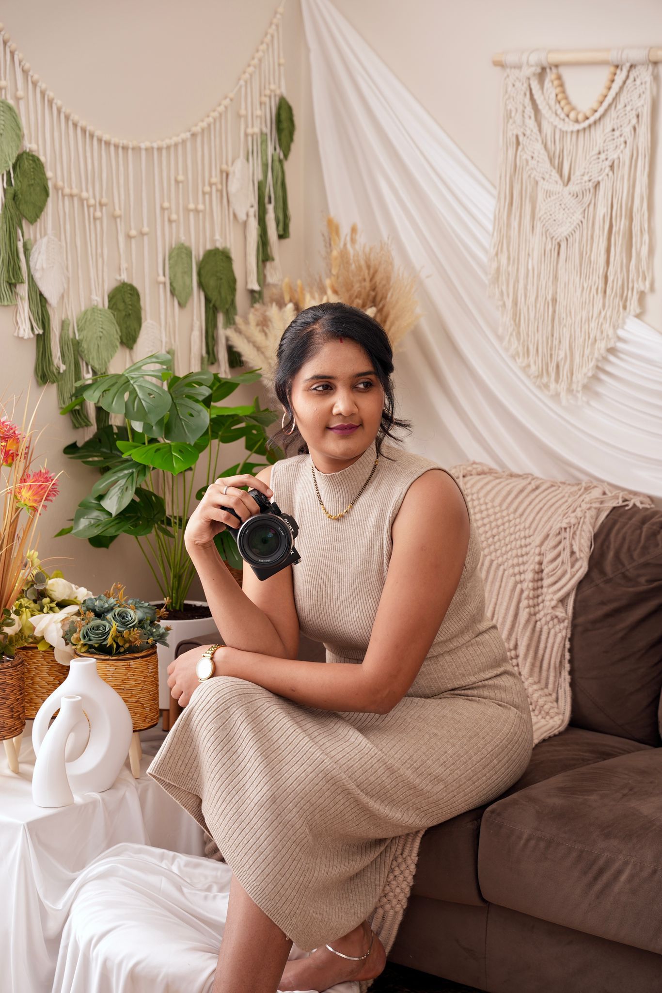 A series of lifestyle photos showing someone in a beige dress posing on a brown couch with macrame wall decor and plants.