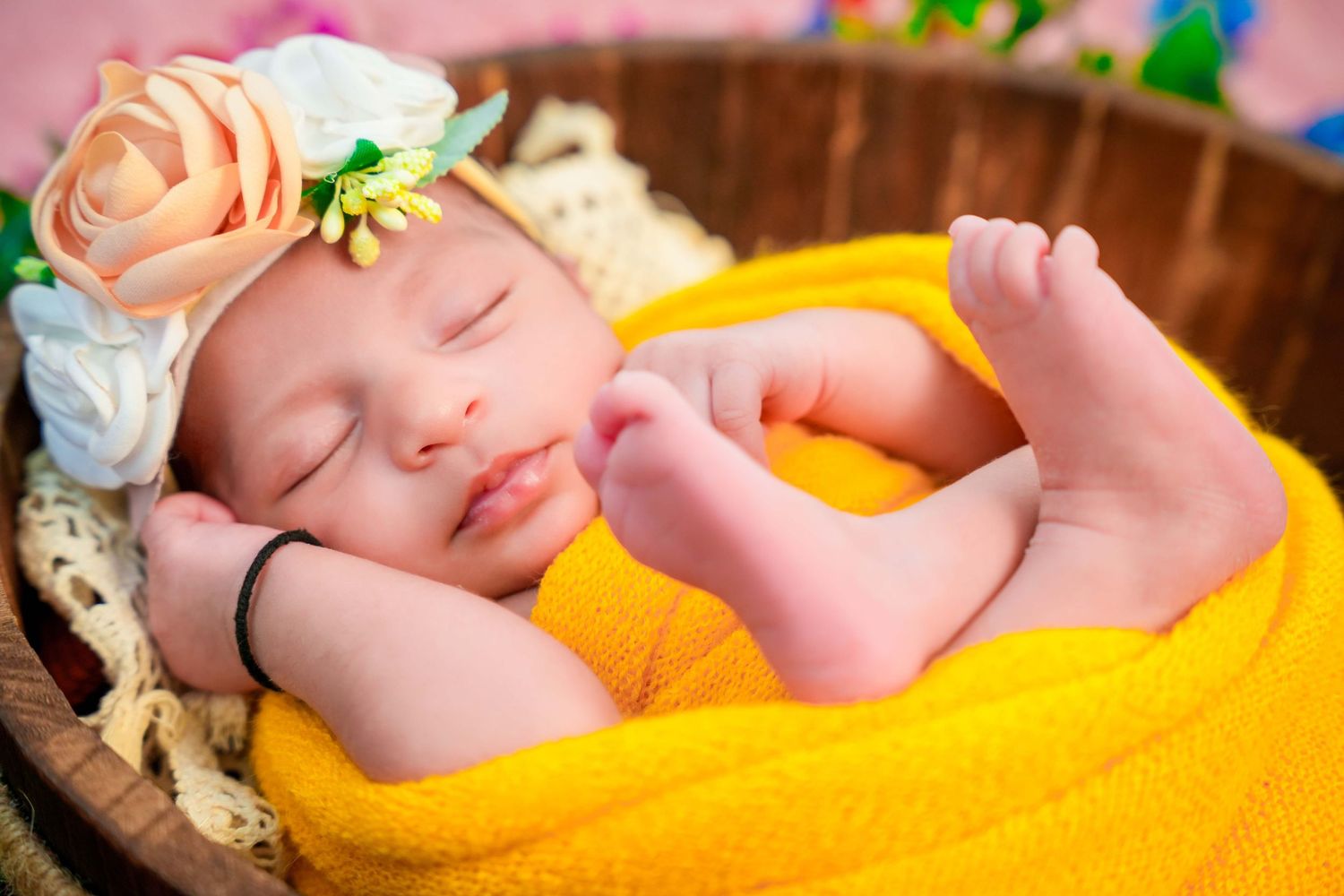 Bright yellow blanket creates warm setting for newborn photography session.