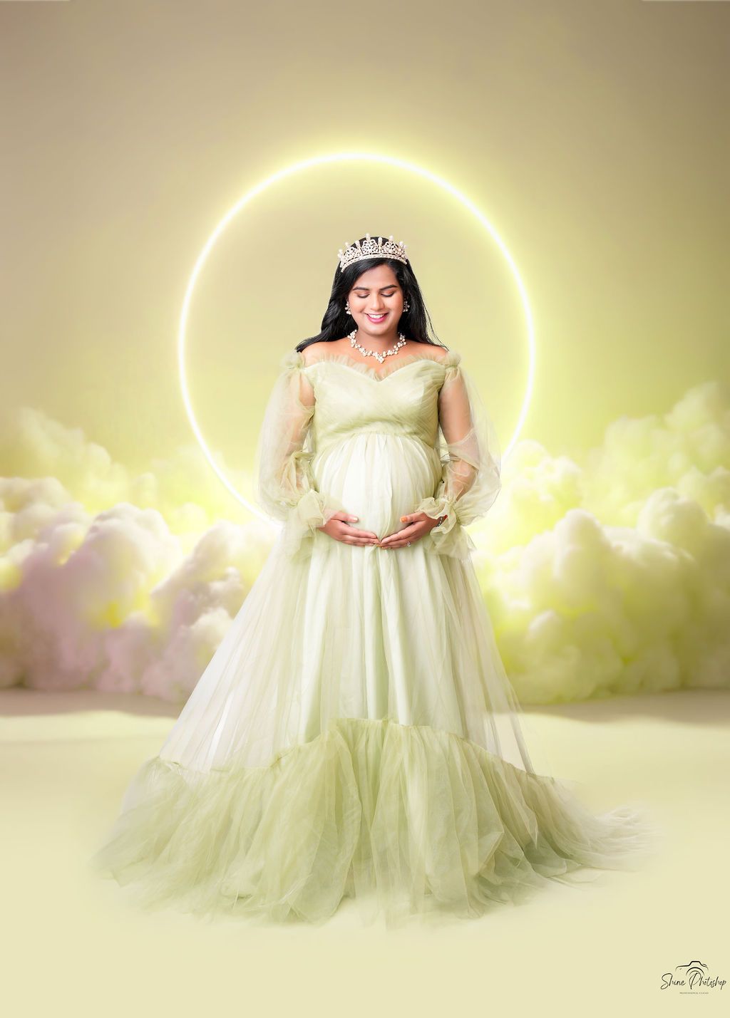 Dreamy maternity portrait with glowing halo effect and flowing white dress.