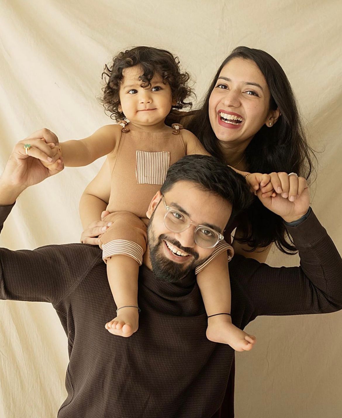 Candid family moments captured against cream colored background.