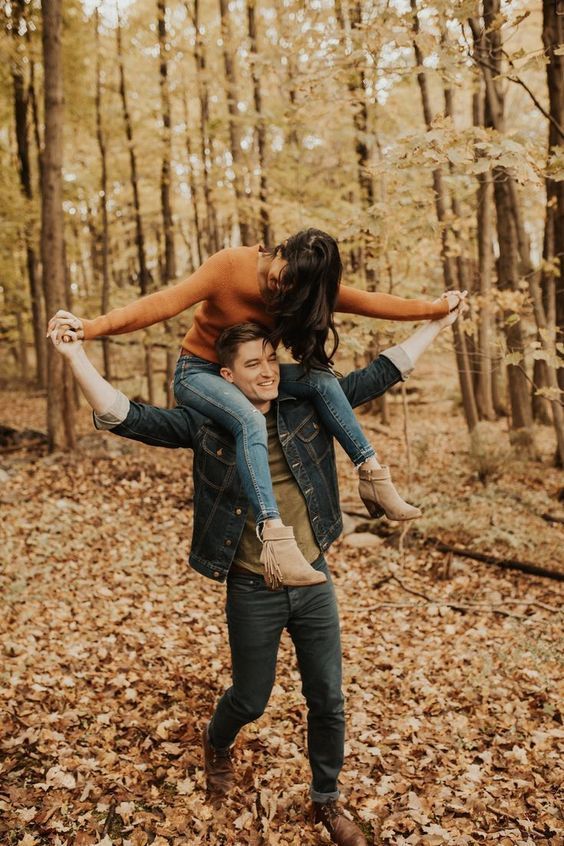 Playful dance moves captured in an autumn forest with fallen leaves.