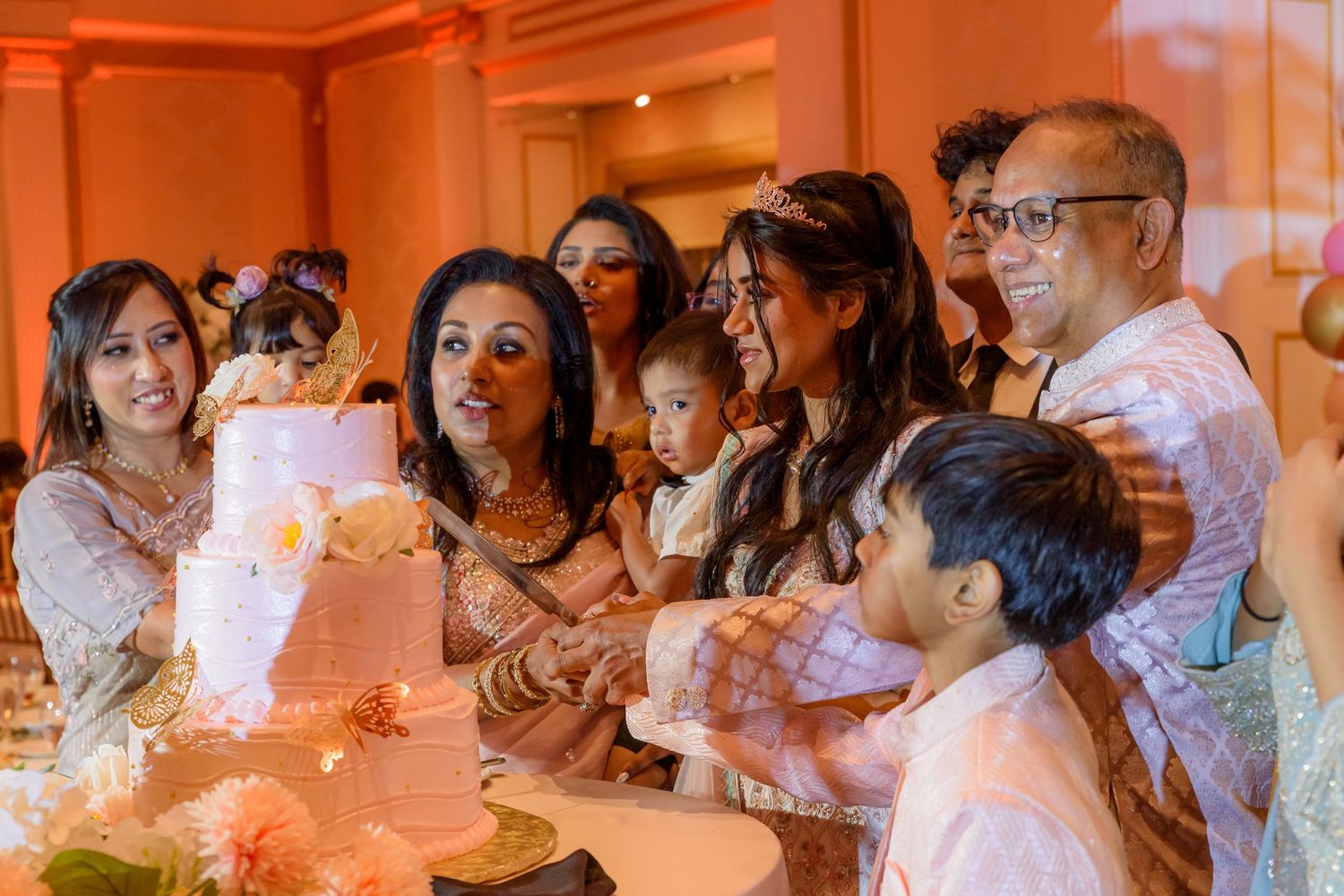 Guests watching a performance in an elegantly lit ballroom with orange ambient lighting.