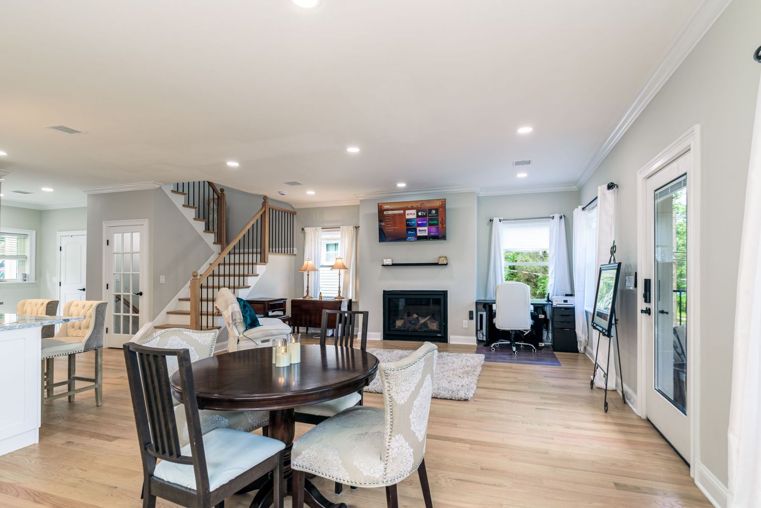 Open concept living space with hardwood floors and recessed lighting in a modern home.