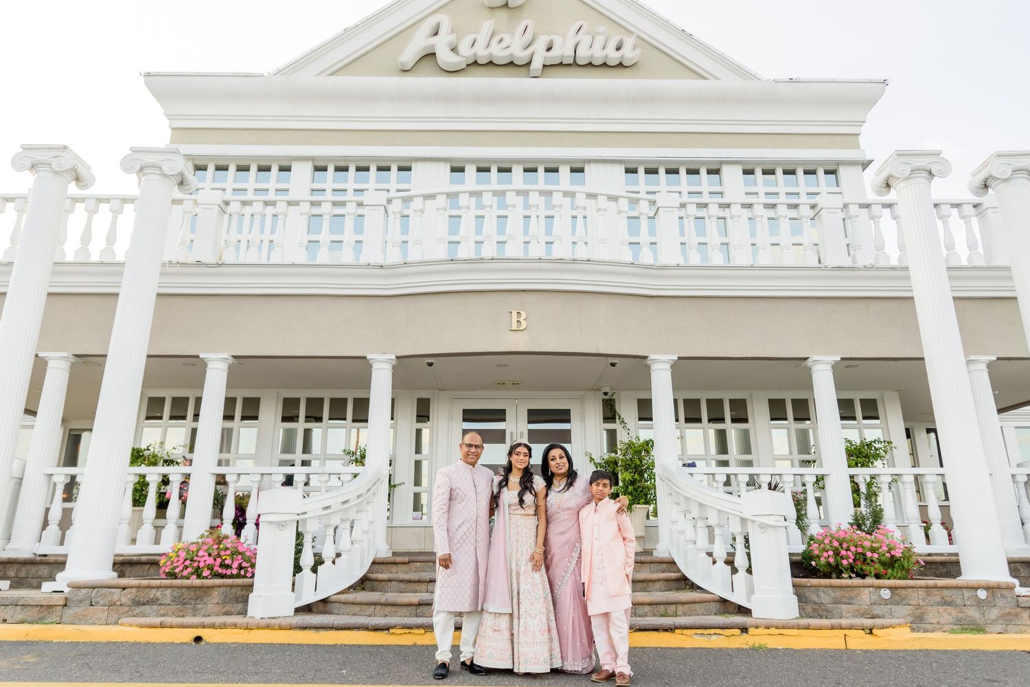 A series of white columned porches and verandas with pink accents at a Southern-style wedding venue.