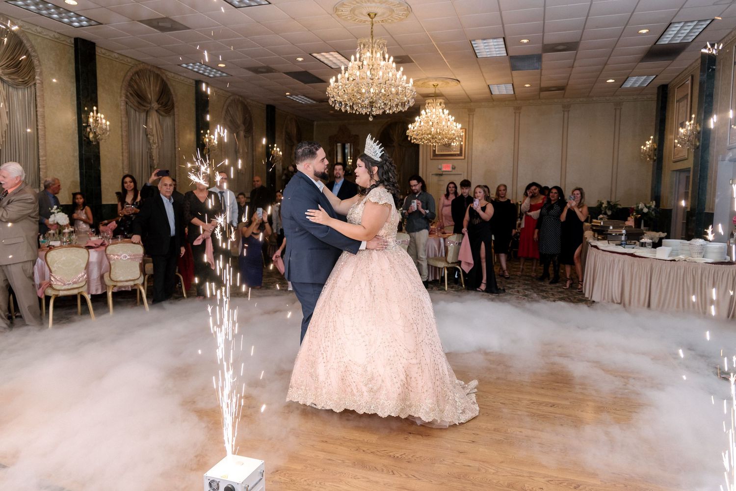 Panoramic view of an elegant ballroom decorated with chandeliers and white chairs for a formal event.