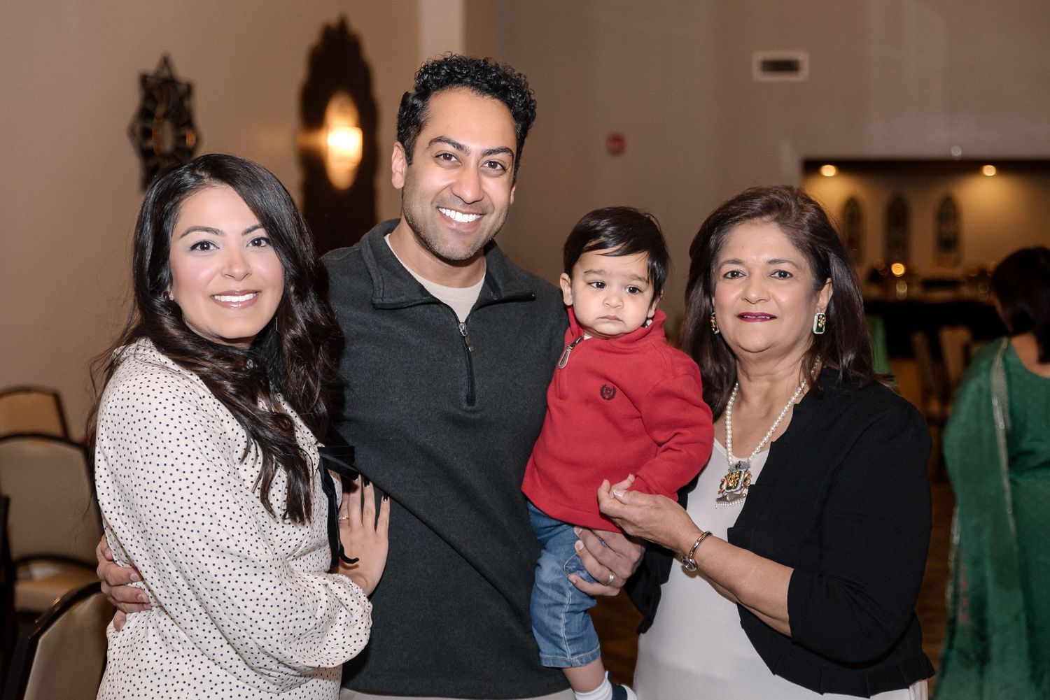 Family gathering in formal attire at an indoor celebration event.