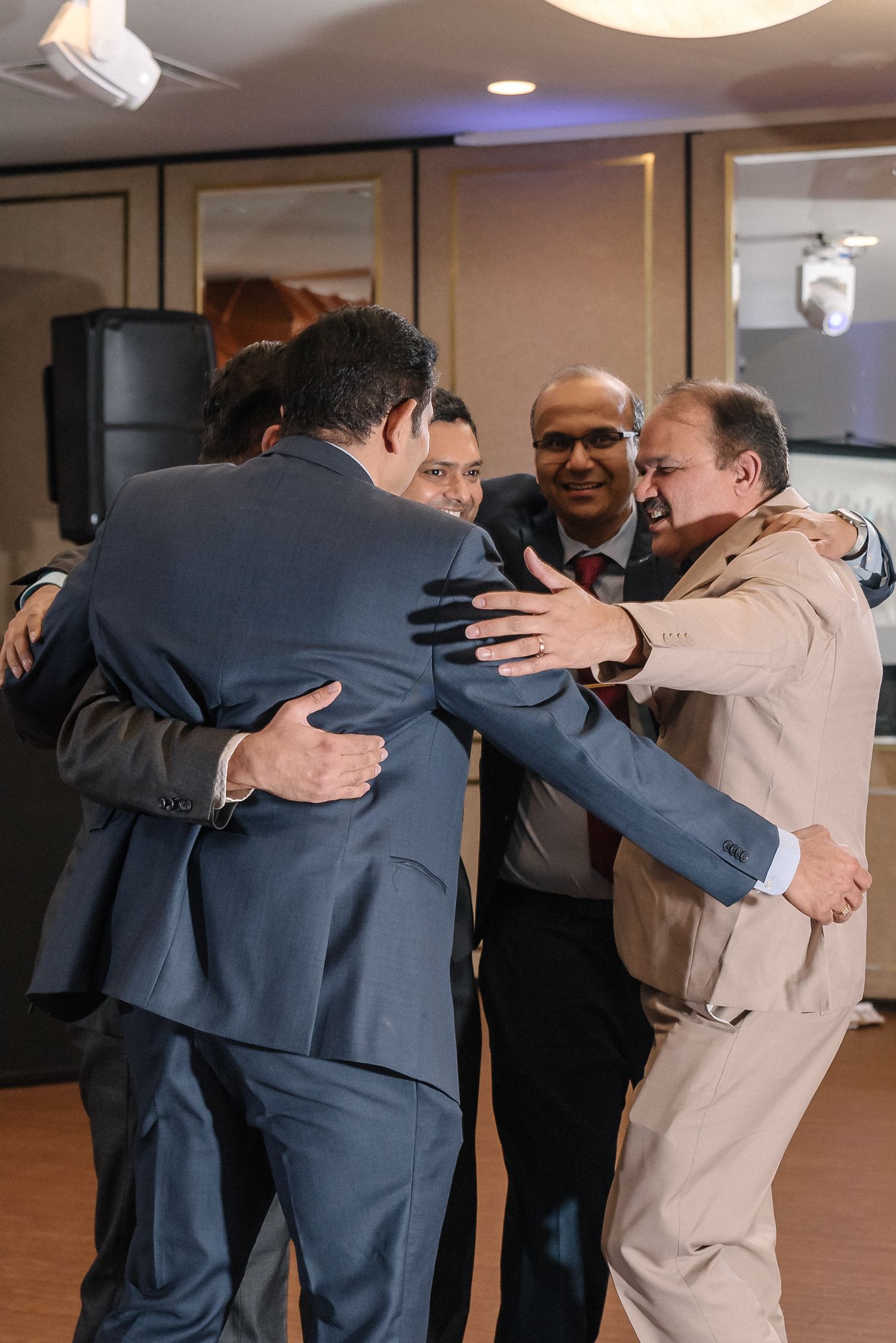 Emotional group hugs shared between party attendees at an indoor celebration.