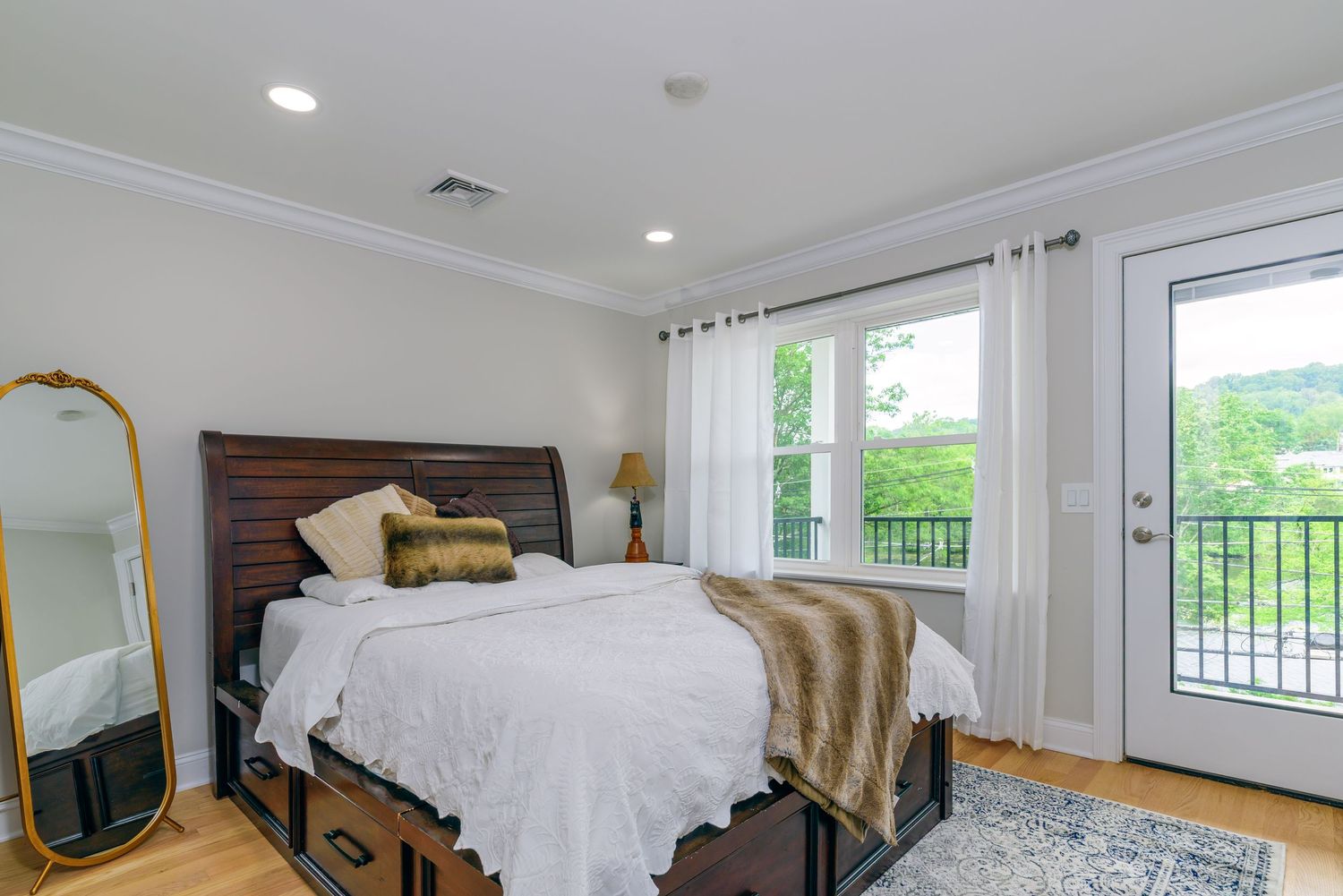 Elegant bedroom with white bedding and balcony access.