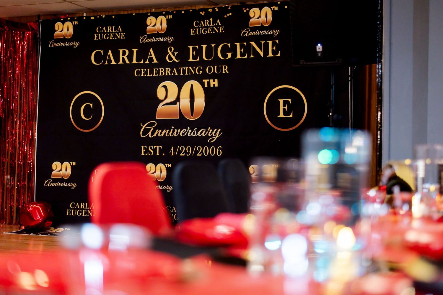 Elegant 20th anniversary party backdrop for Carla & Eugene, established 4/29/2006, with gold and black decor.