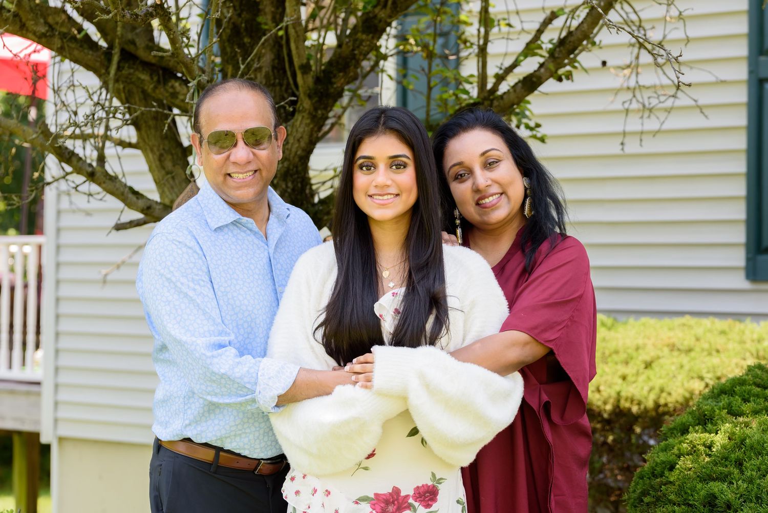 Sweet 16 birthday portraits photoshoot. In the client's home in Marlton, NJ. Birthday girl given a warm hug by her loving parents.