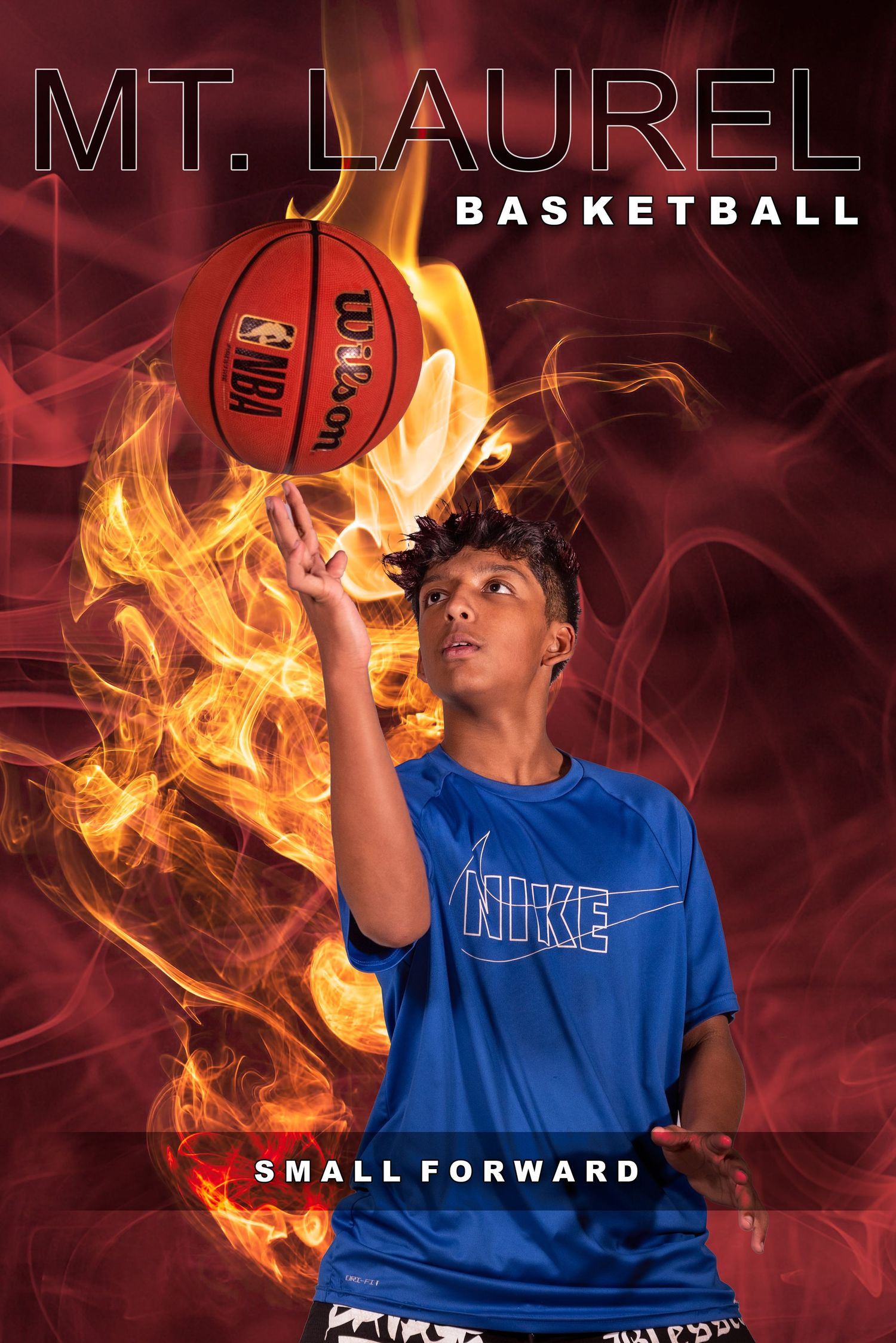 Basketball player in blue jersey poses with dramatic fire effects and smoke in sports photo composite.