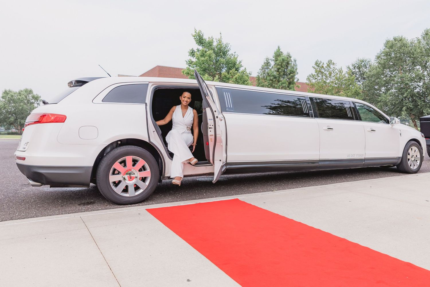 White limousines lined up on red carpet for luxury event arrival.