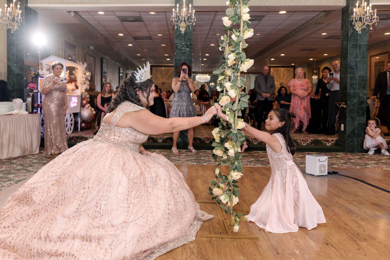 Elegant ballroom with floral arches and chandeliers set up for a formal celebration.