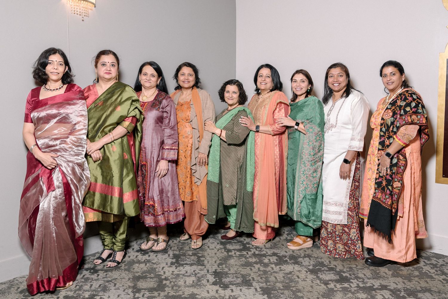 Large group photo of guests in colorful traditional Indian attire at a formal event.