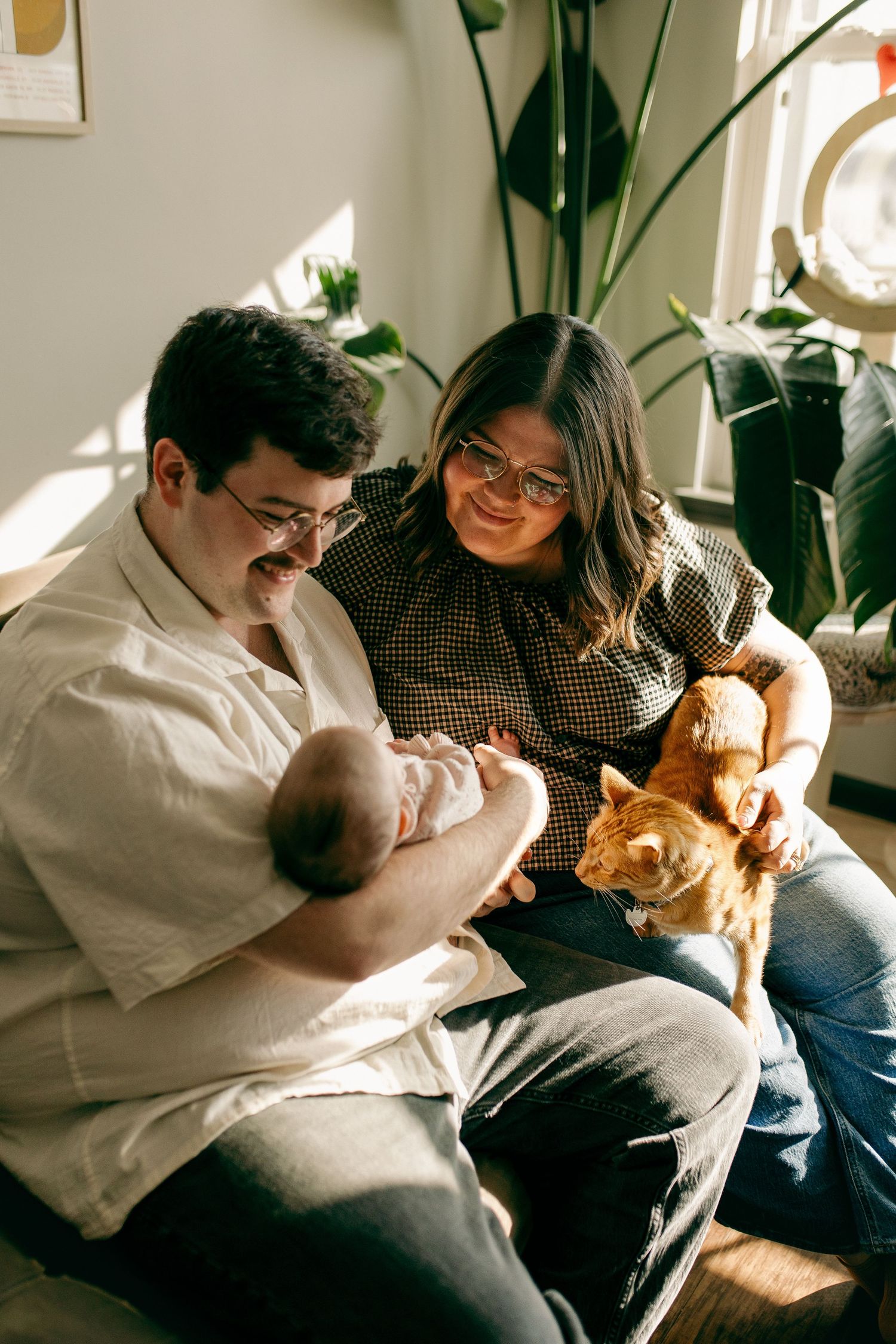 A new mom and dad holding their newborn at a newborn photo session