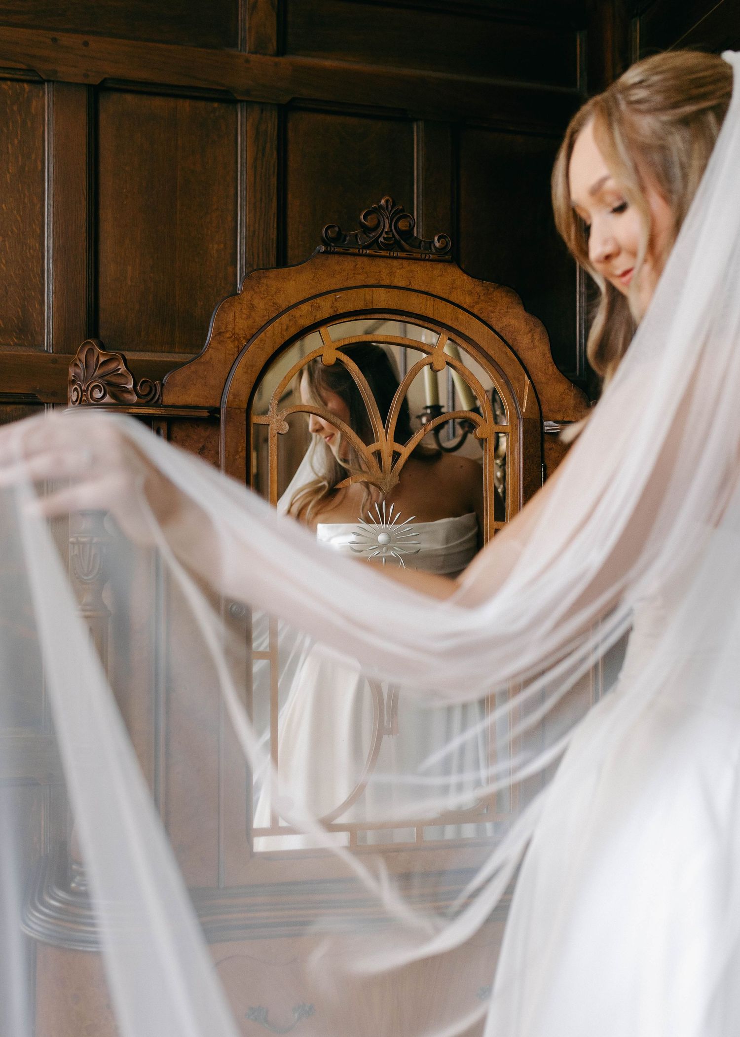 A bride standing in front of a mirror on her wedding day