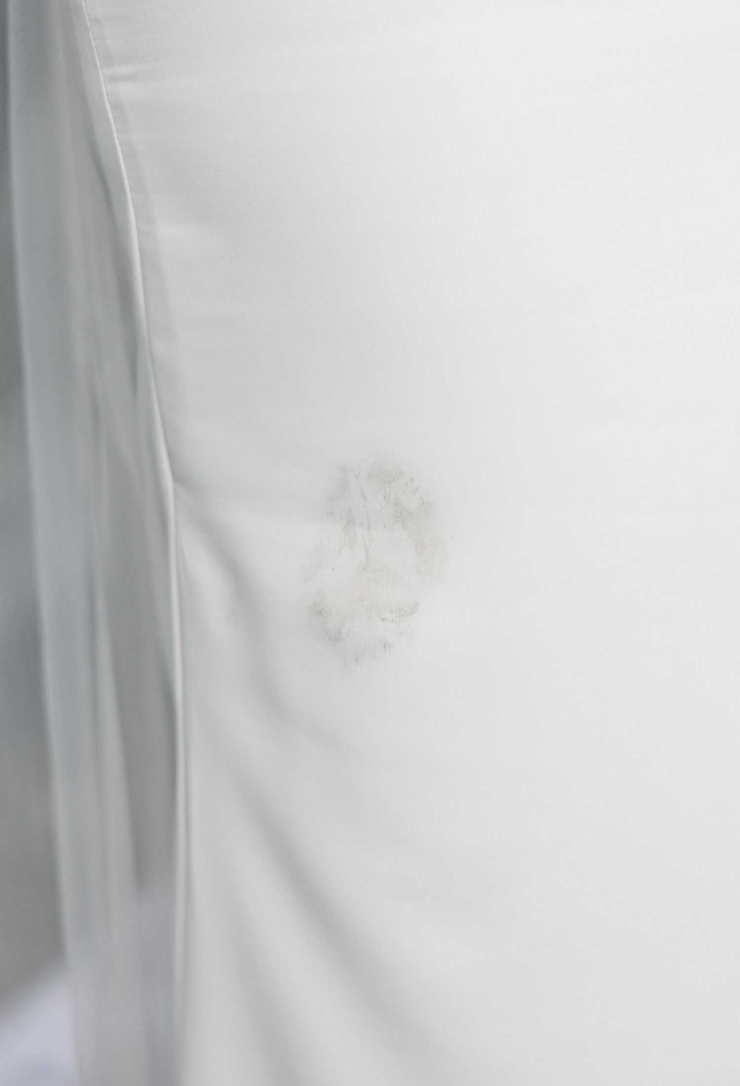 Close-up of delicate embroidered monogram detail on a white wedding veil fabric.