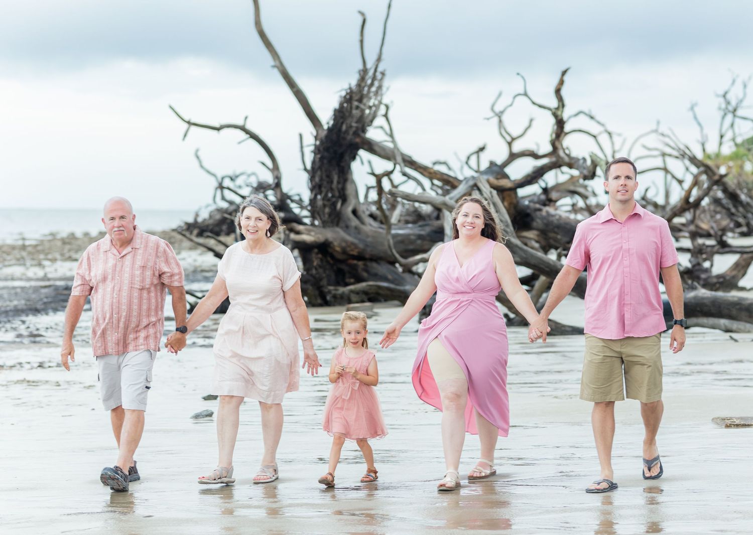 A series of beachfront family portraits showing parents with children walking and splashing in the surf at sunset.
