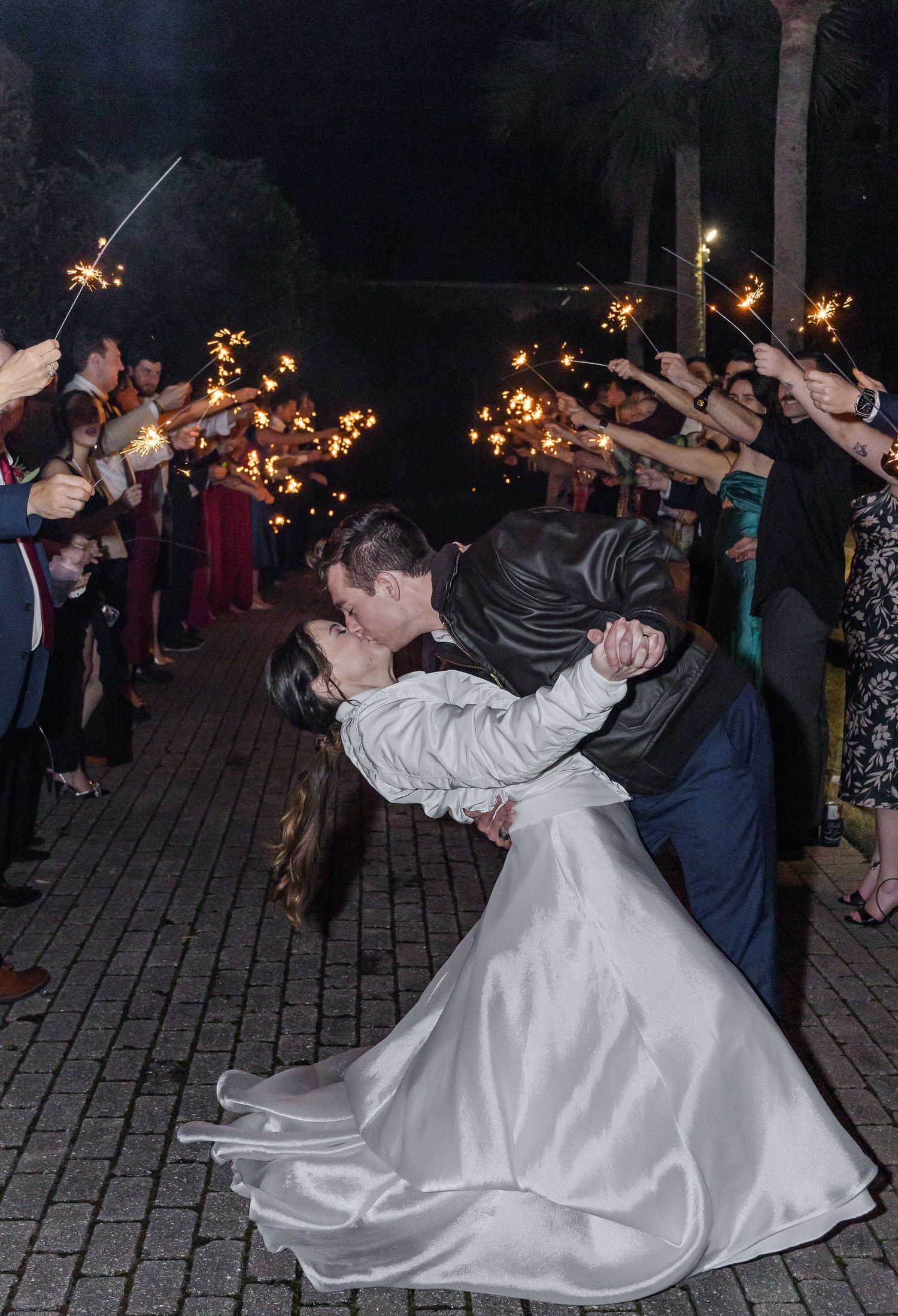Elegant sparkler exit with couple dancing as guests line the brick walkway.
