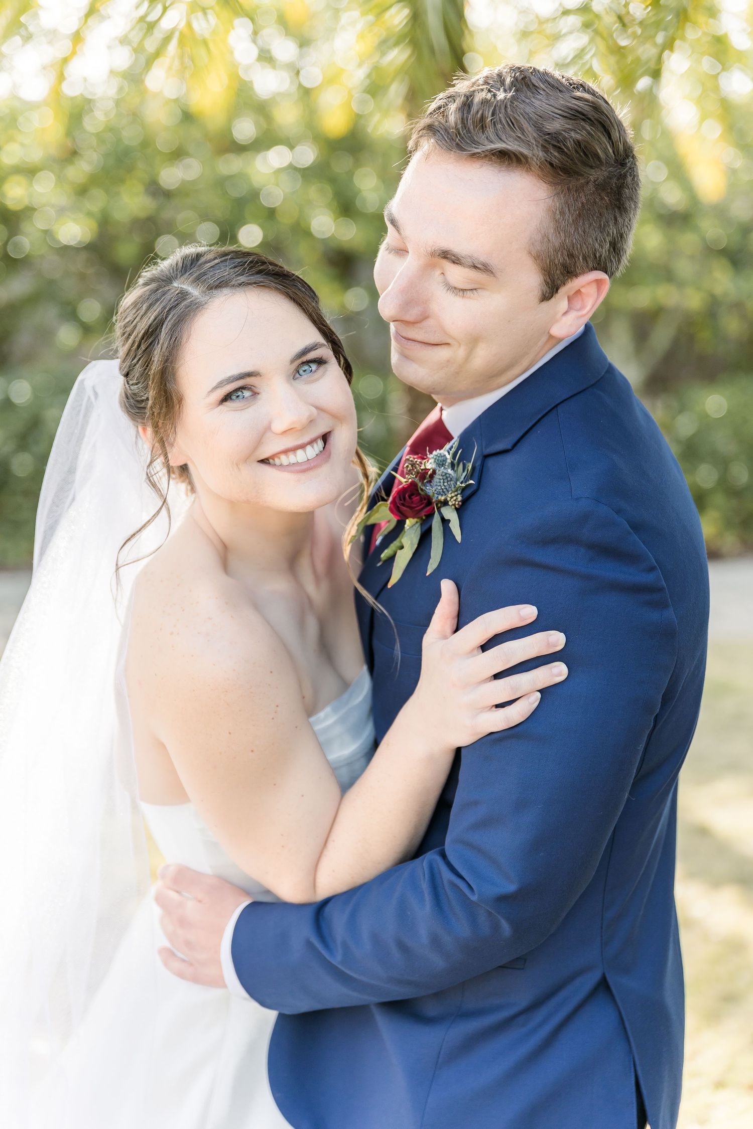 Wedding couple embracing outdoors with soft natural lighting.