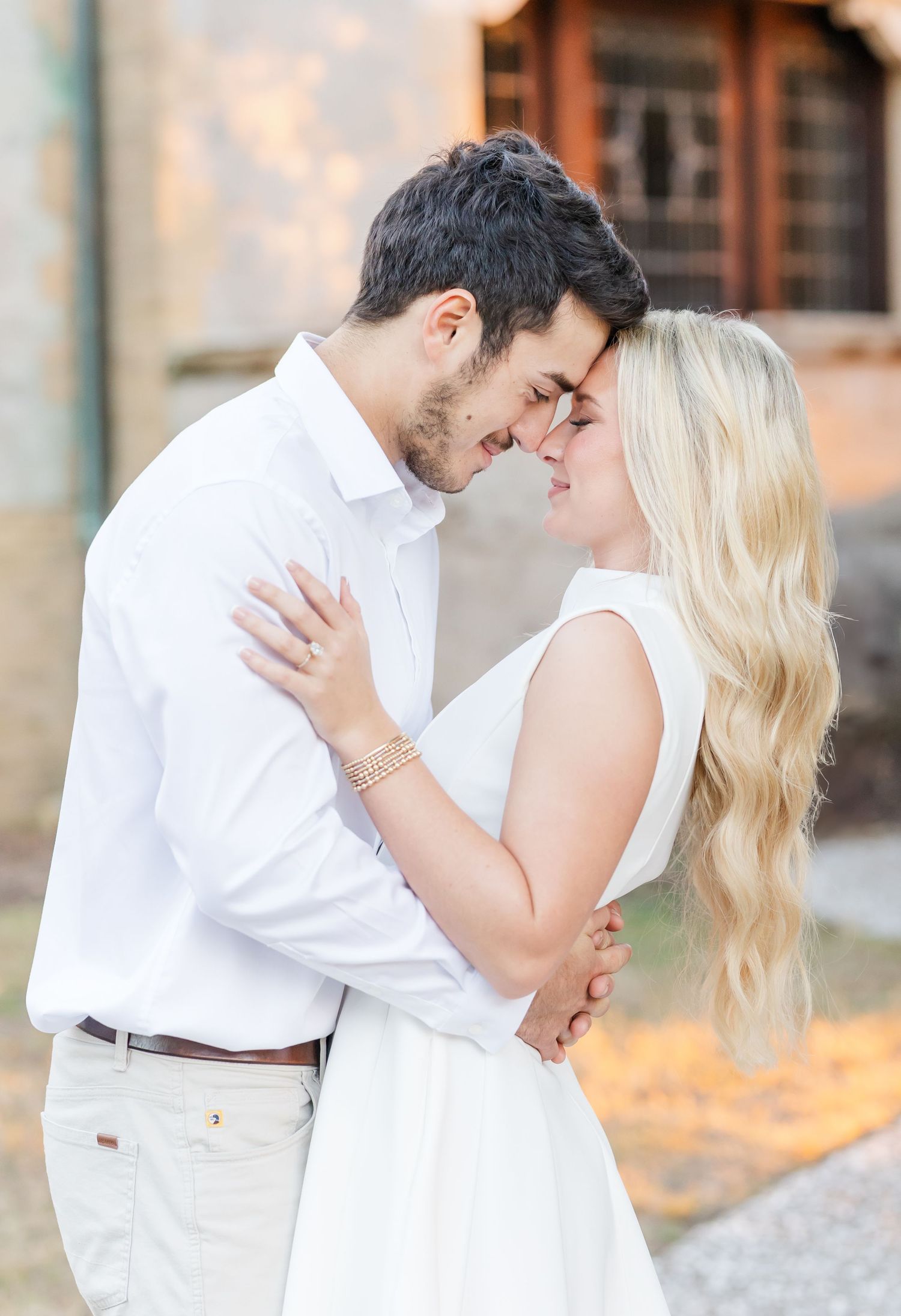 Romantic couple in white outfits sharing intimate moments during a photo session.