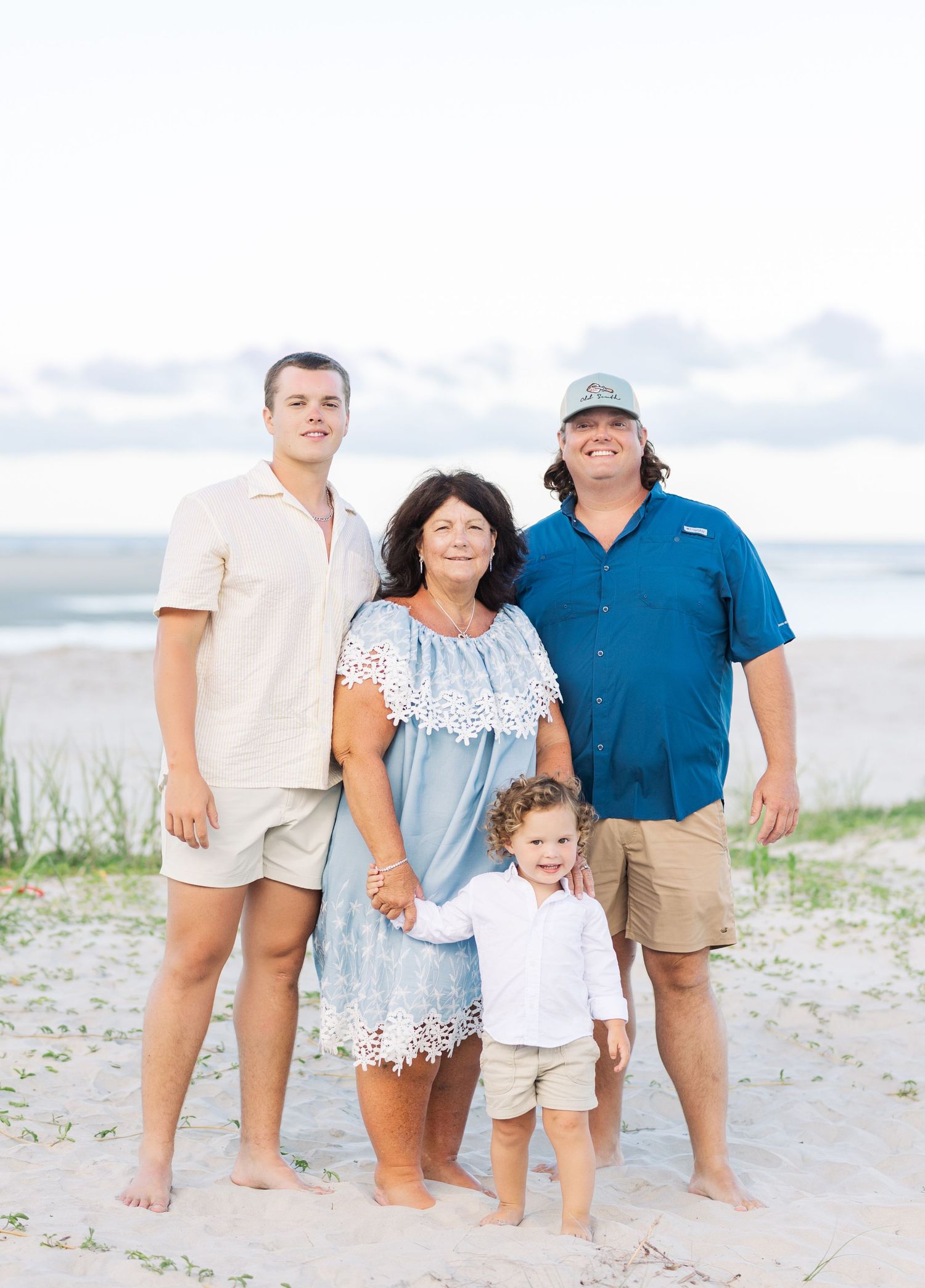 Extended family gathering for a casual beach portrait in summer attire.