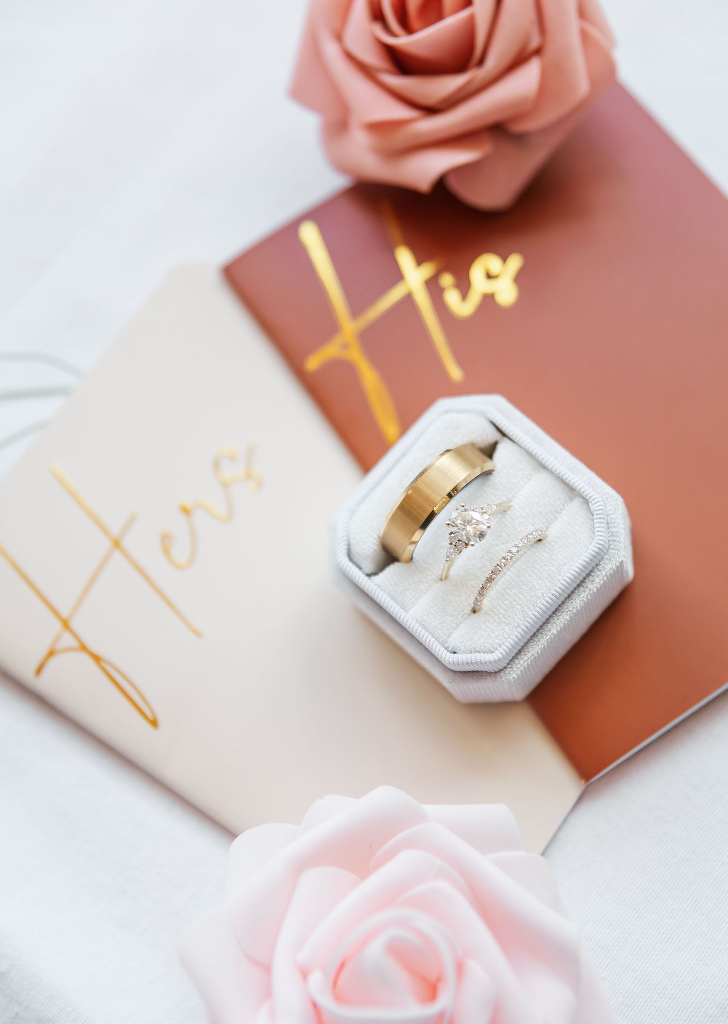 Wedding ring box and coral roses styled with gold lettering on blush and terracotta cards for romantic flat lay.