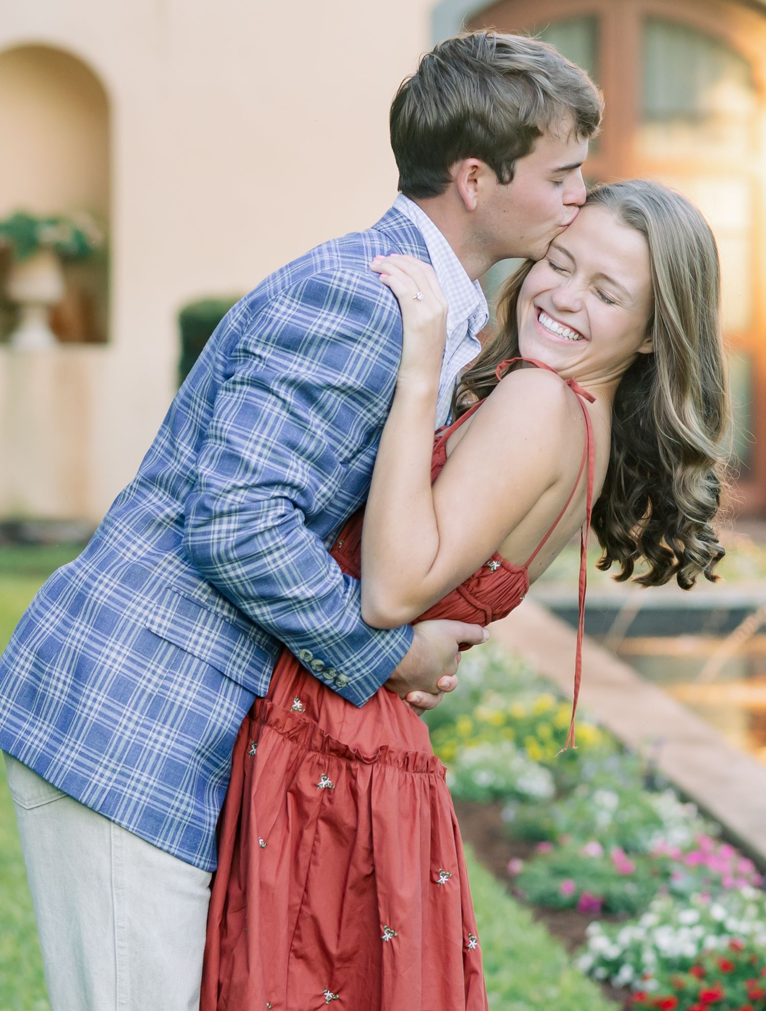 A romantic couple shares an intimate moment in a garden setting during golden hour.