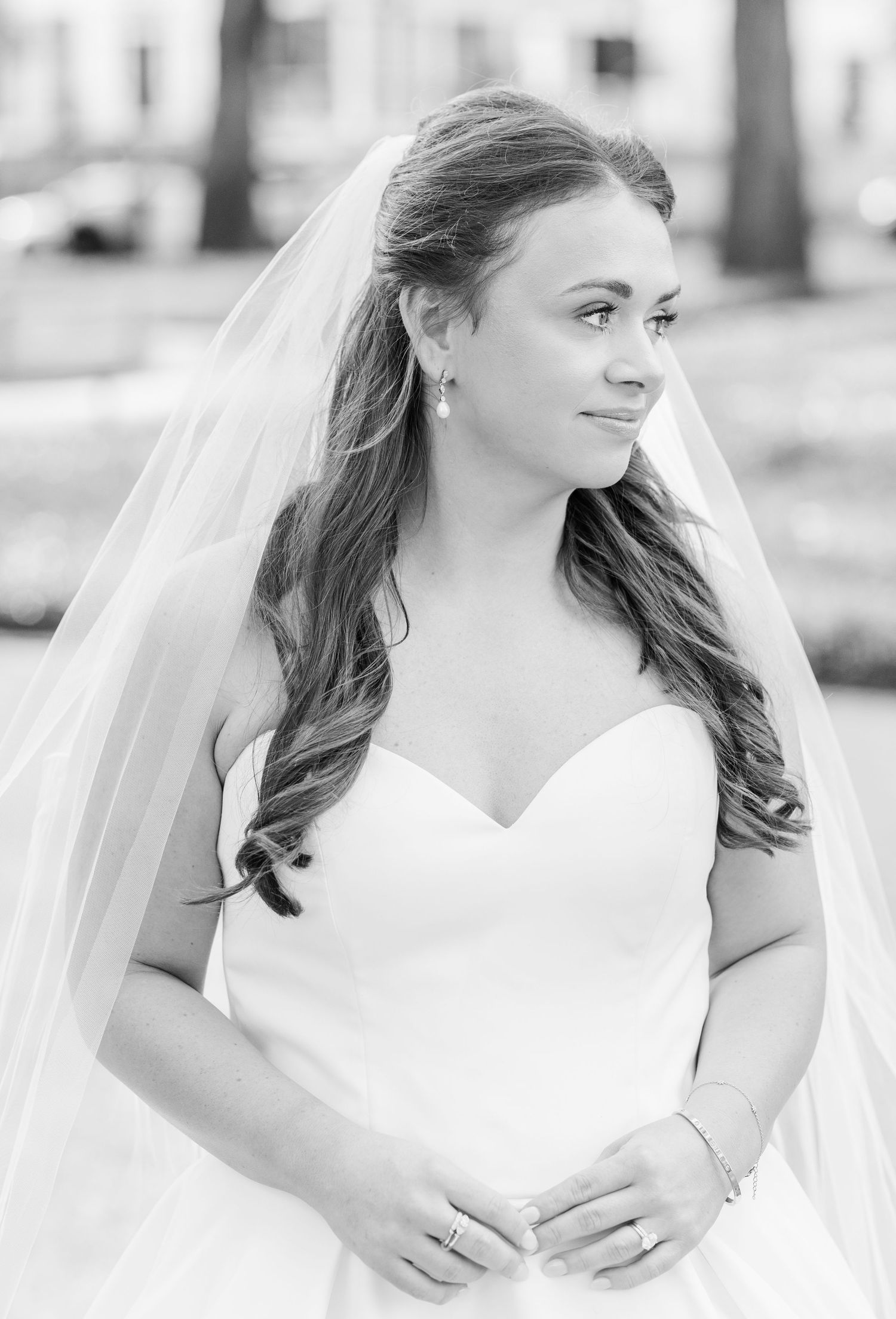 Romantic bridal portraits in soft black and white showing flowing veil and elegant white gown.