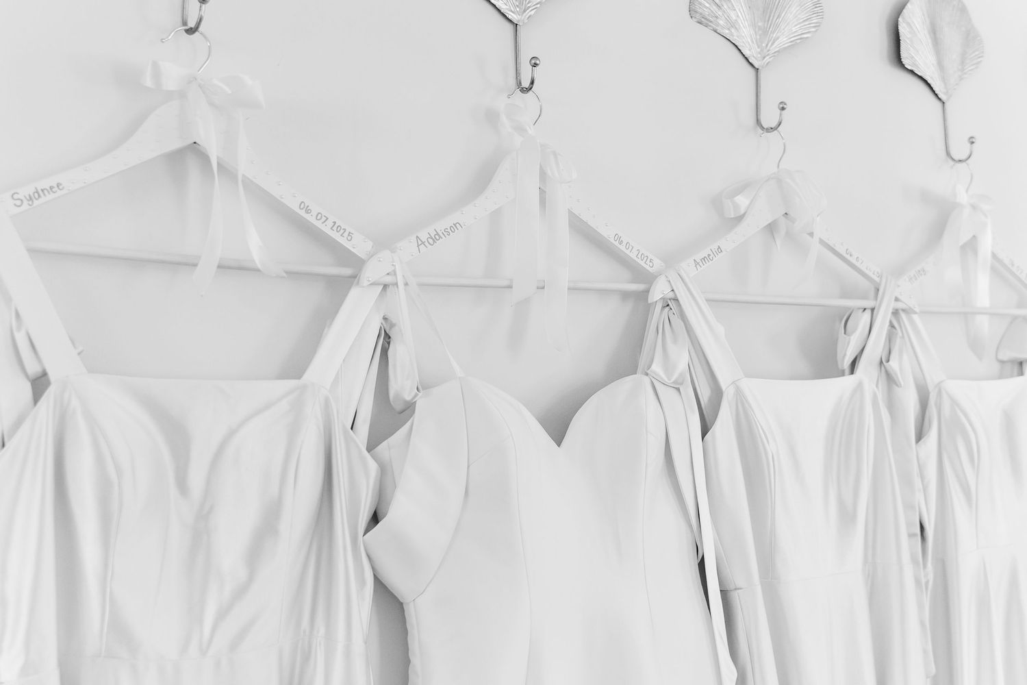 White wedding dresses hanging on display hooks in a bridal boutique.