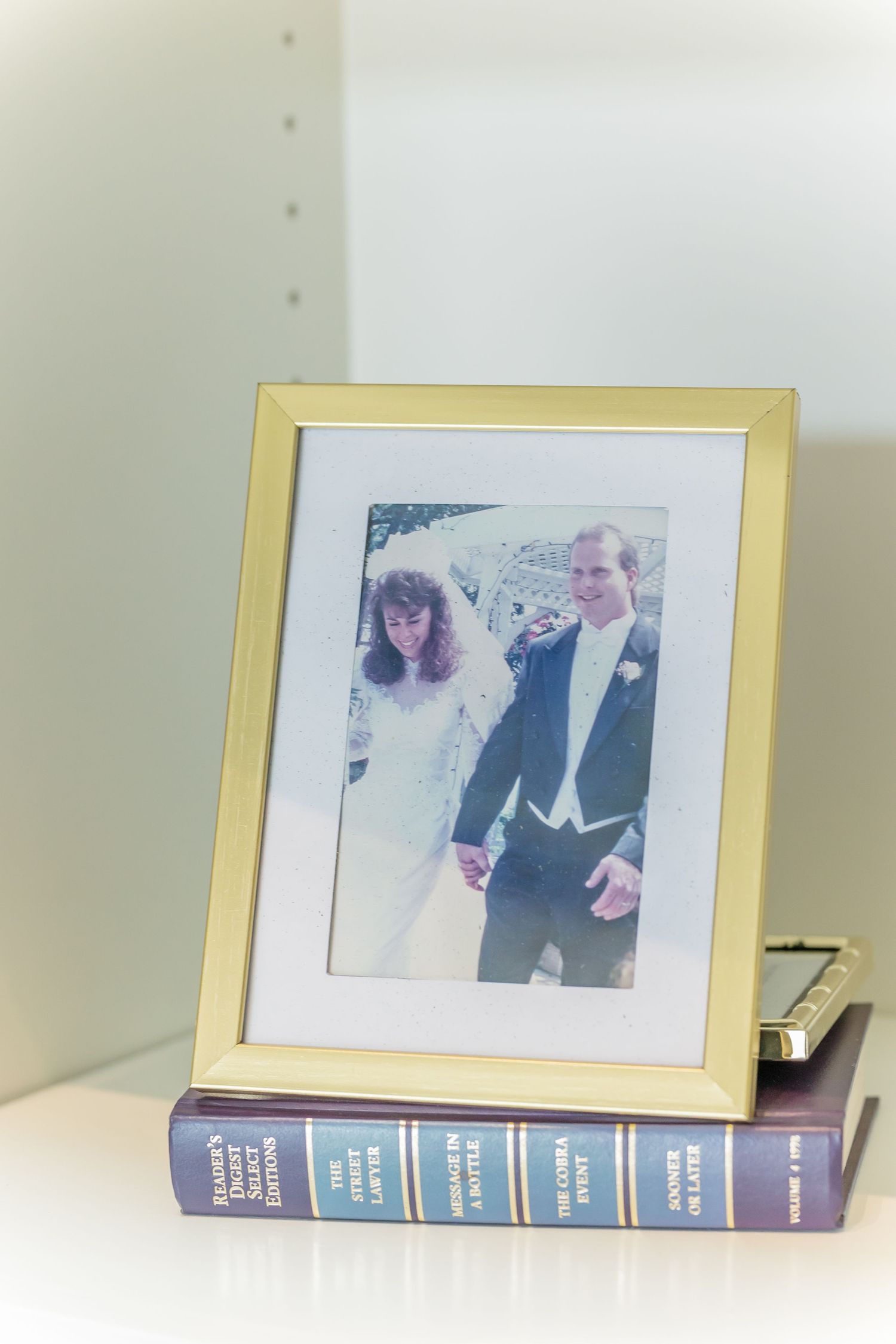 Vintage framed photograph displayed on purple books creating a decorative vignette.