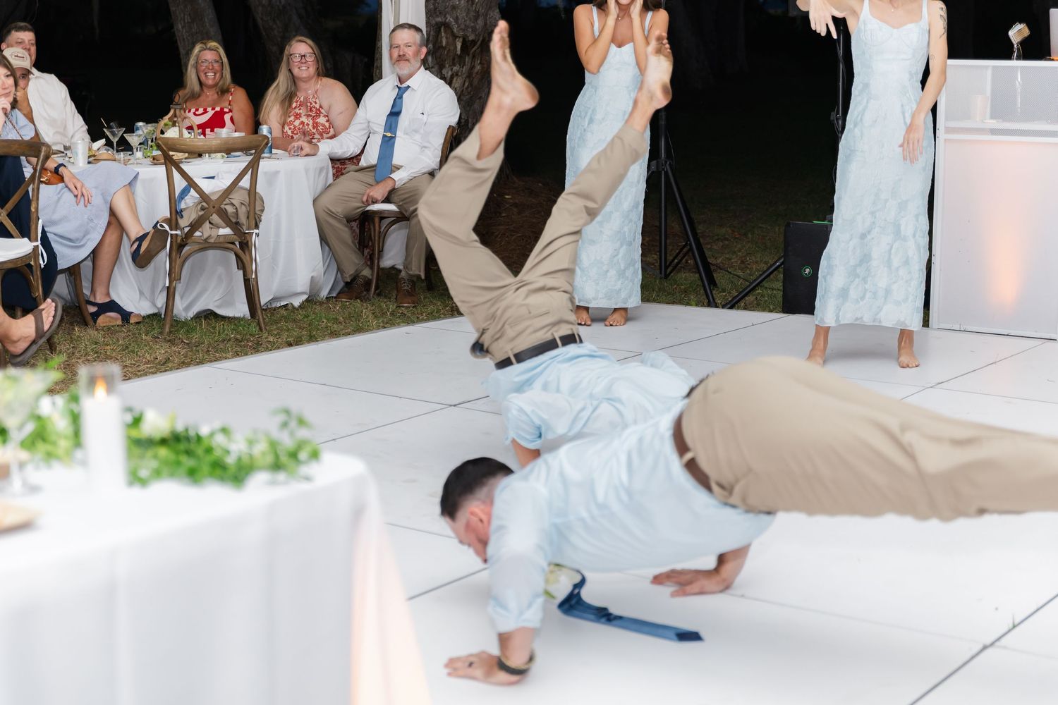 Wedding guests dancing and celebrating on an outdoor dance floor at night.